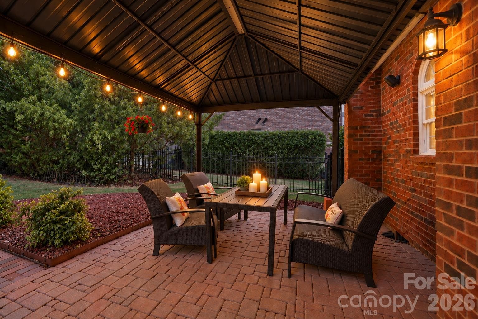 As evening settles in, the covered patio becomes an inviting place to linger over dinner, share a bottle of wine or spend a quiet evening outside. The soft lighting and sheltered setting create the kind of outdoor space you’ll want to use well beyond the daylight hours. - 2309 Highland Forest Drive, Waxhaw