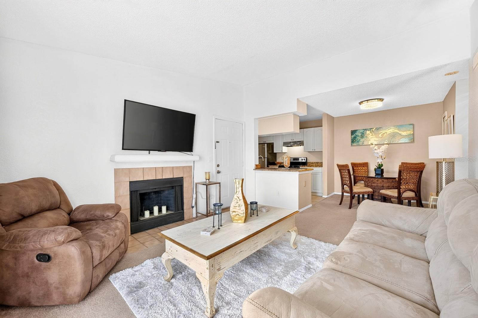 Filled with NATURAL LIGHT, the Living Room features a FIREPLACE and glass-paneled doors that open to the COVERED, SCREENED BALCONY. - 2550 N ALAFAYA TRL #6303, ORLANDO