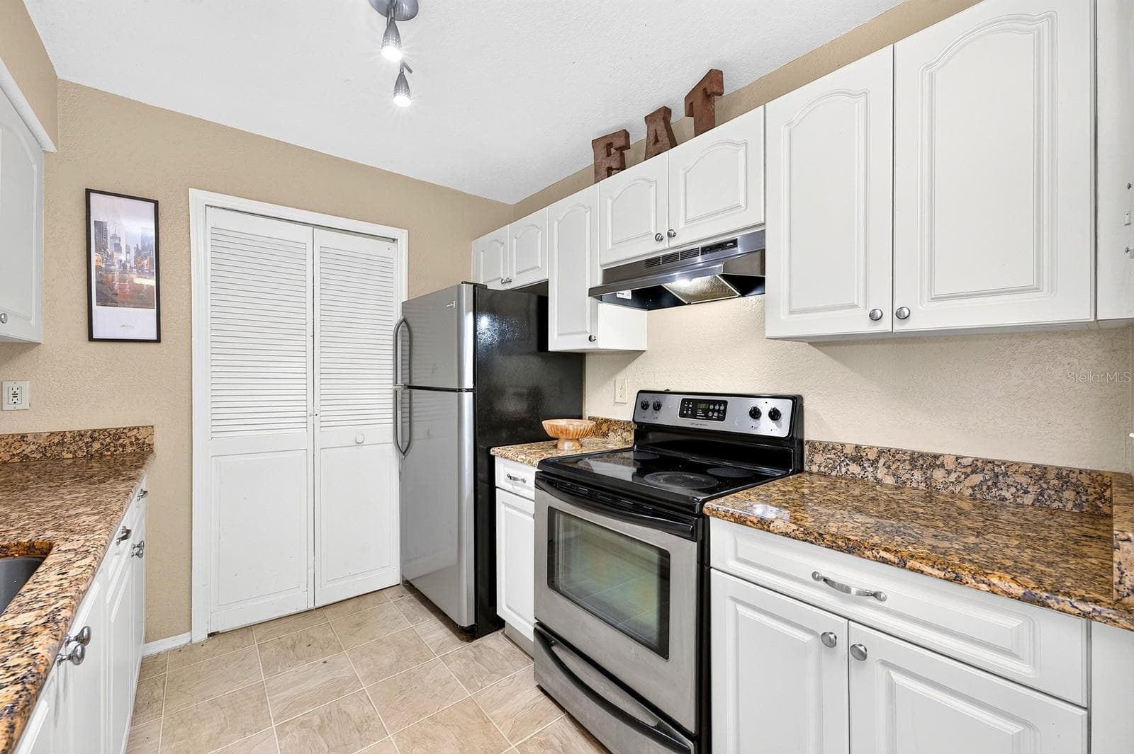 A convenient LAUNDRY ROOM IS TUCKED BEHIND A CLOSET DOOR in the Kitchen, keeping the washer and dryer easily accessible while neatly out of sight. - 2550 N ALAFAYA TRL #6303, ORLANDO