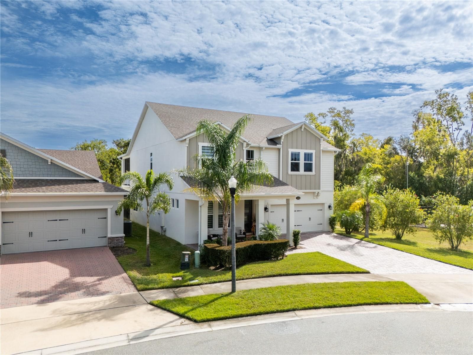 Elevated front view showcasing elegant curb appeal, tropical landscaping, and a two-car garage. - 1316 SOUTHERN SUN DRIVE, OAKLAND