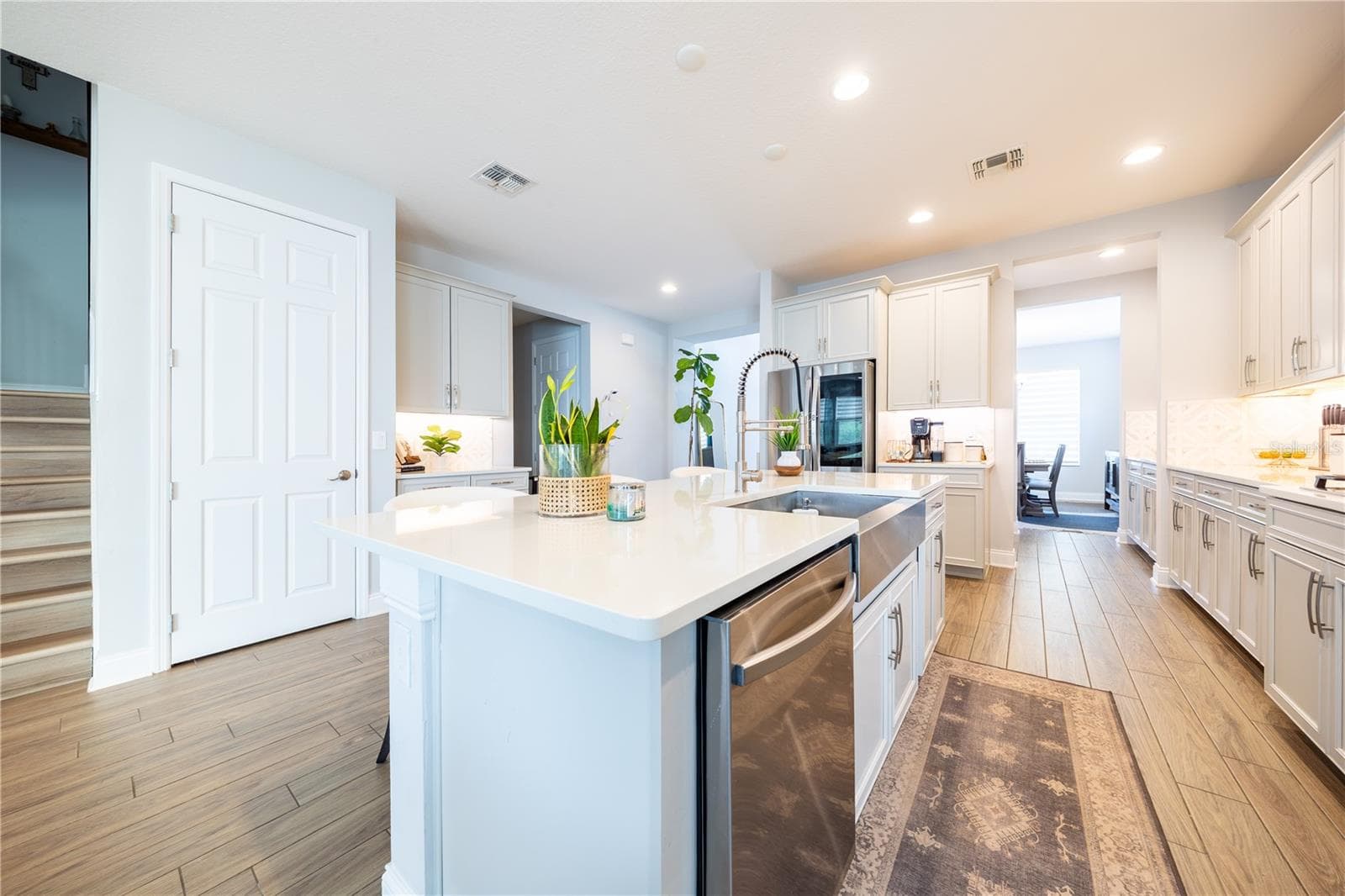 Spacious kitchen island featuring a stainless steel apron-front sink, pull-down faucet, and integrated dishwasher. - 1316 SOUTHERN SUN DRIVE, OAKLAND