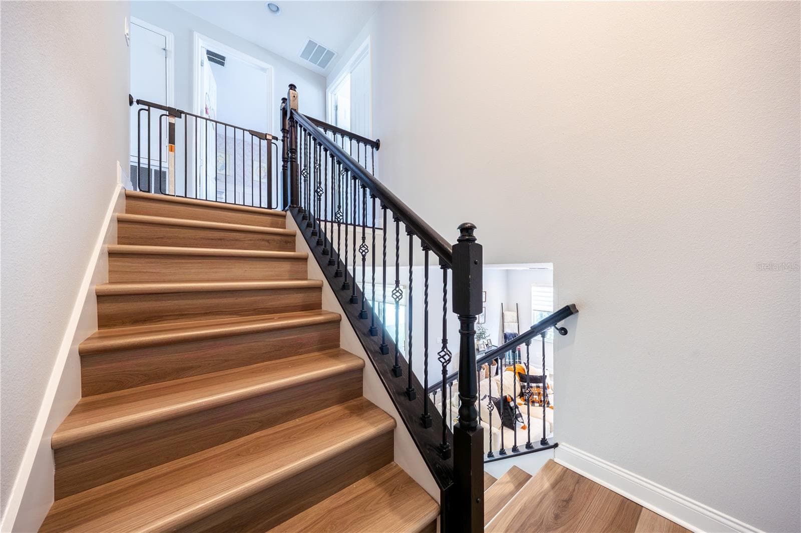 Elegant staircase with warm wood-look finishes and decorative metal railings leading to the upper level. - 1316 SOUTHERN SUN DRIVE, OAKLAND