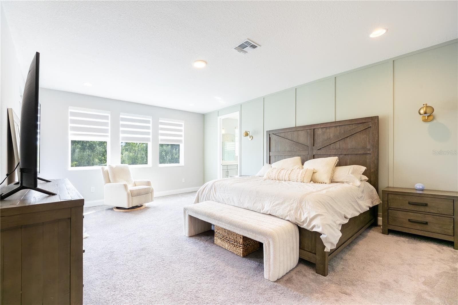 Spacious primary bedroom with an elegant accent wall, sitting area, and porch access with views of a conservation area. - 1316 SOUTHERN SUN DRIVE, OAKLAND
