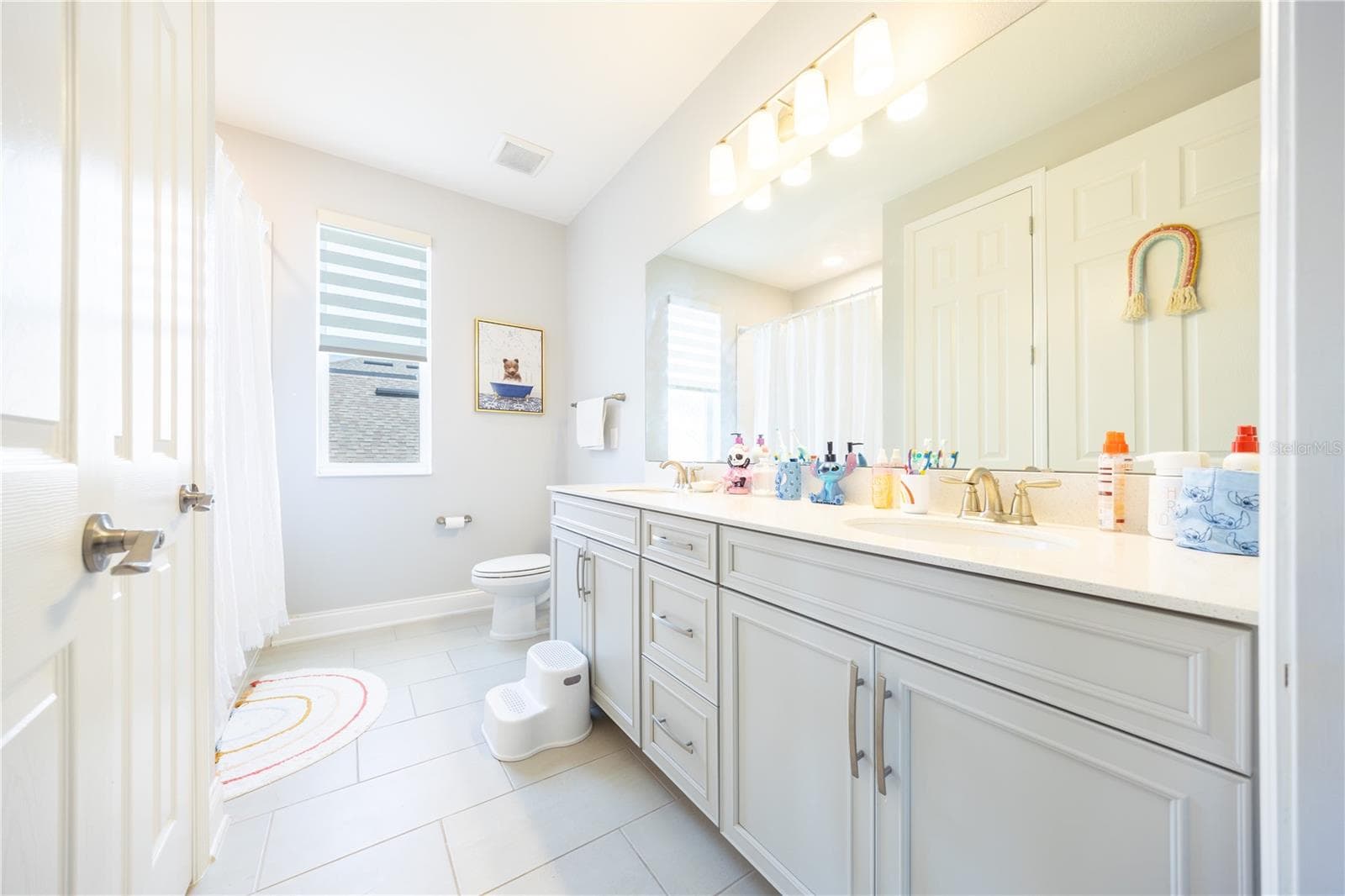 Spacious bathroom with a dual-sink vanity, expansive mirror, and ample cabinet storage. - 1316 SOUTHERN SUN DRIVE, OAKLAND