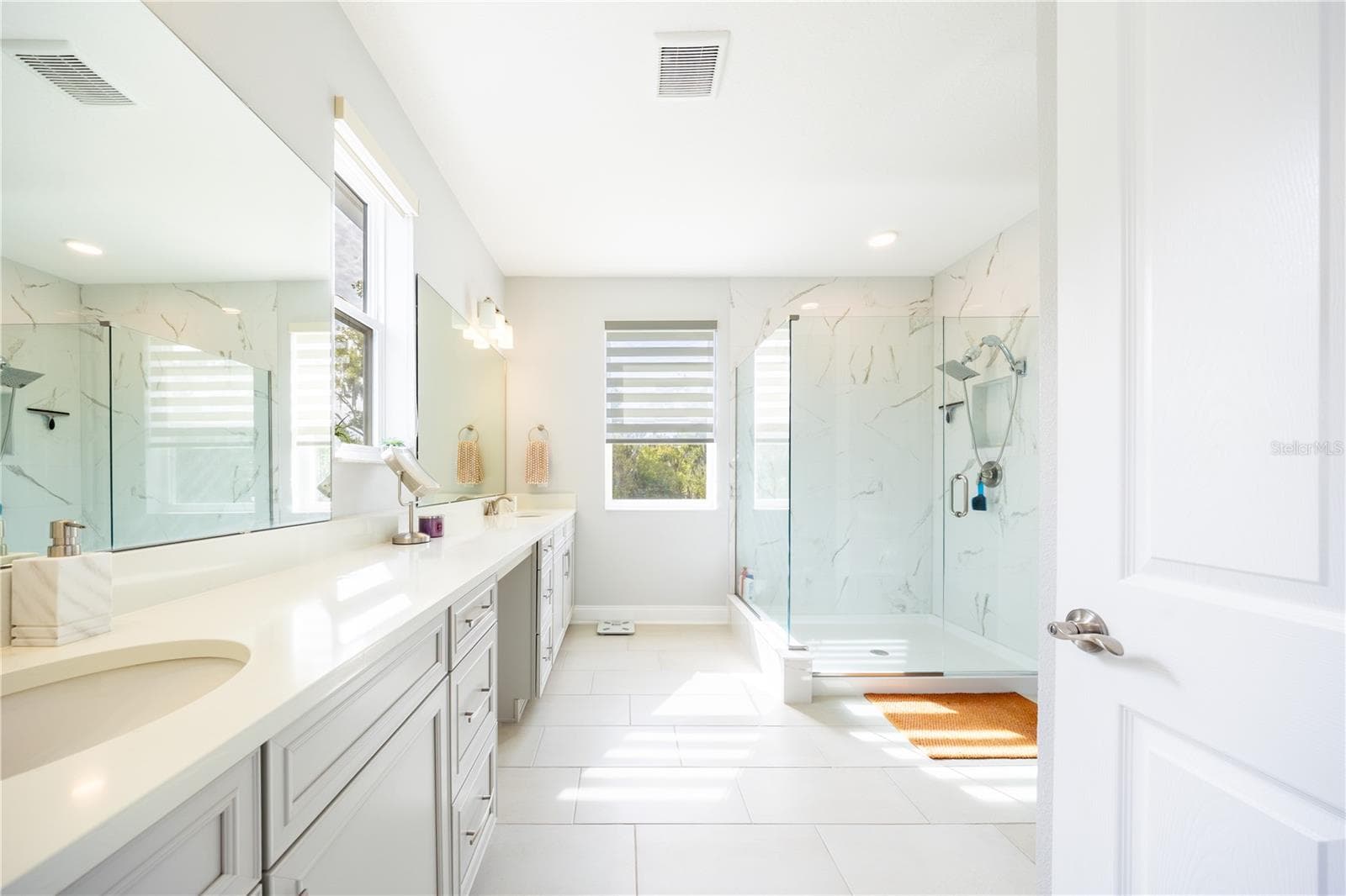 Spacious primary bathroom with a dual-sink vanity, makeup area, and frameless glass shower. - 1316 SOUTHERN SUN DRIVE, OAKLAND
