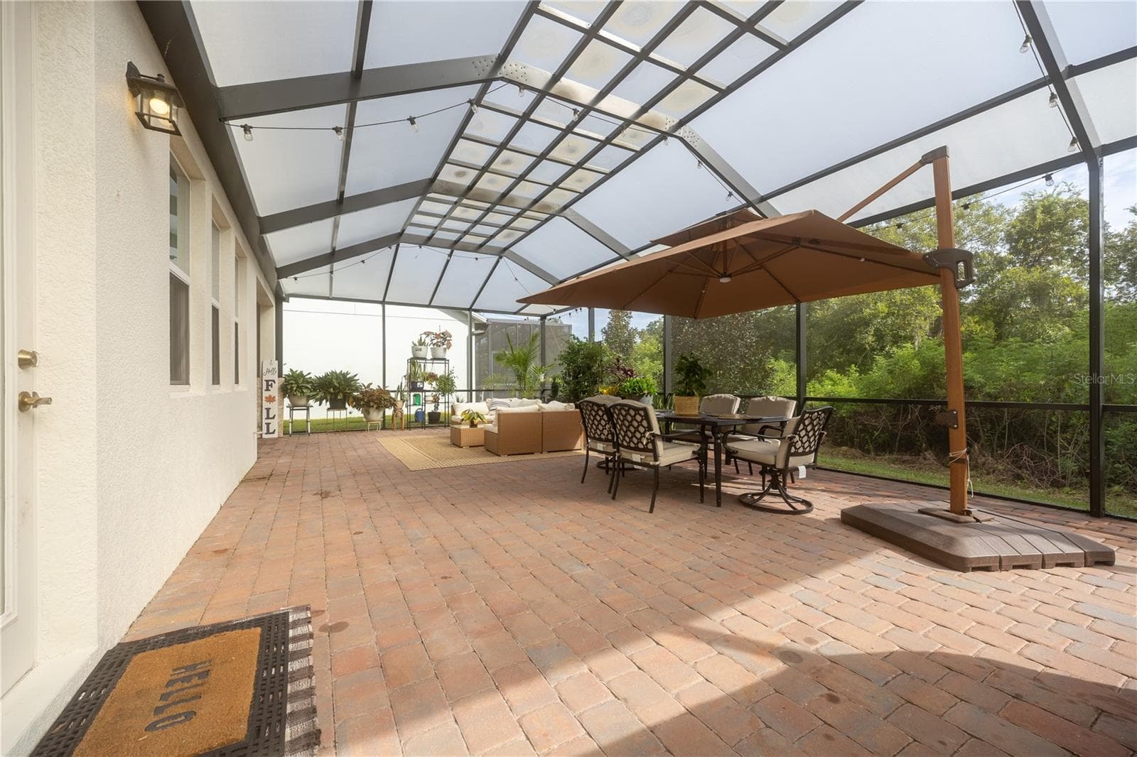 Expansive screened patio with paver flooring, outdoor dining, and peaceful conservation views. - 1316 SOUTHERN SUN DRIVE, OAKLAND
