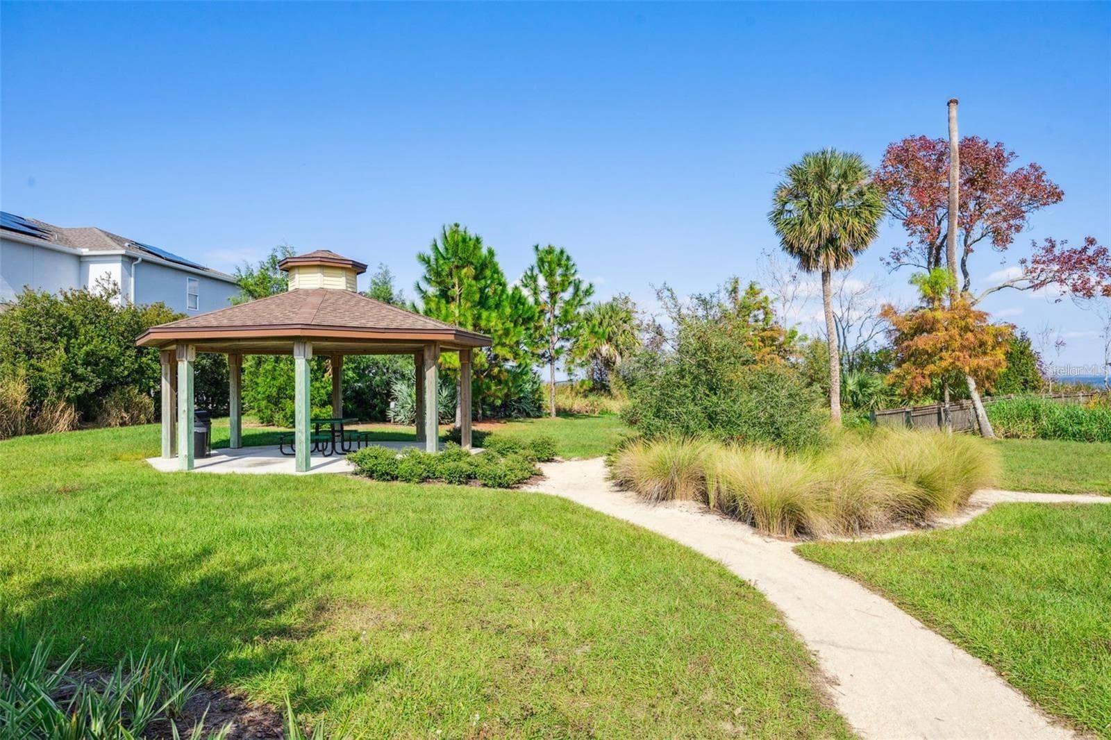 Covered picnic pavilion surrounded by lush landscaping, with a walking path leading toward the lake. - 1316 SOUTHERN SUN DRIVE, OAKLAND