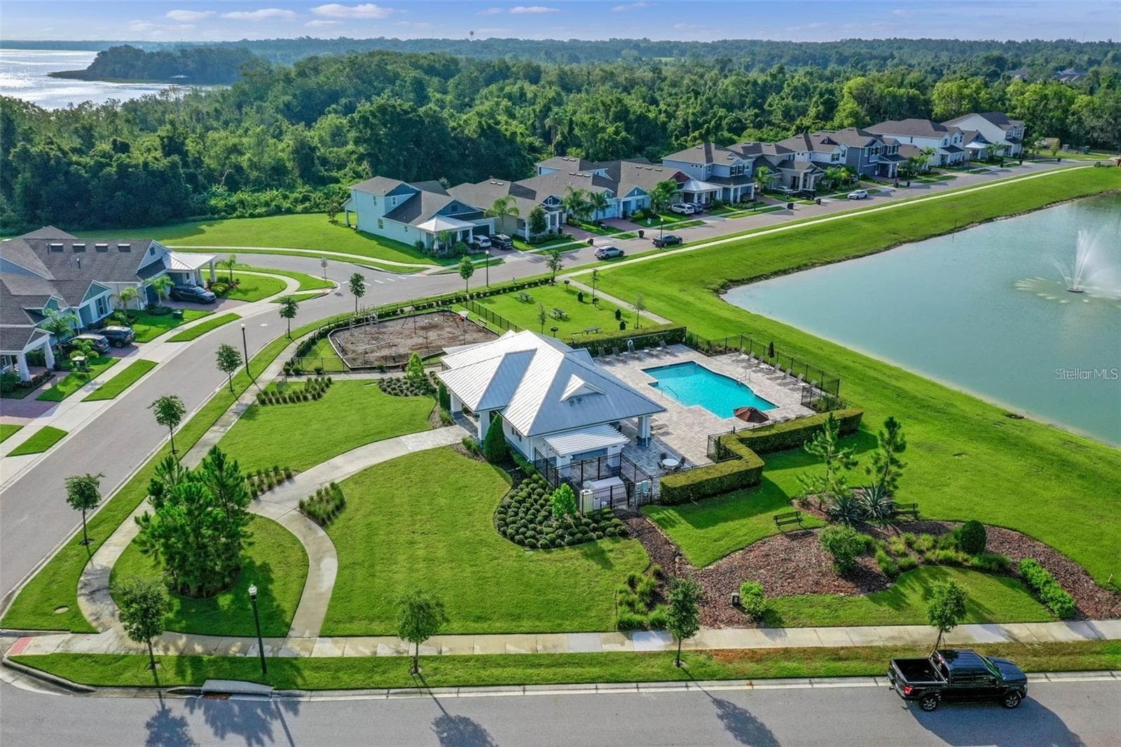 Aerial view of the community pool, playground, and landscaped walking paths beside a scenic pond. - 1316 SOUTHERN SUN DRIVE, OAKLAND