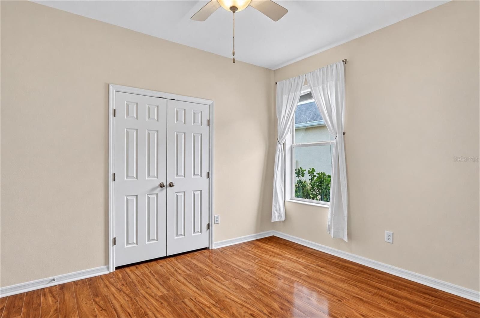 Freshly painted bedroom with hardwood flooring and closet storage. - 2153 BARRACUDA CT, HOLIDAY