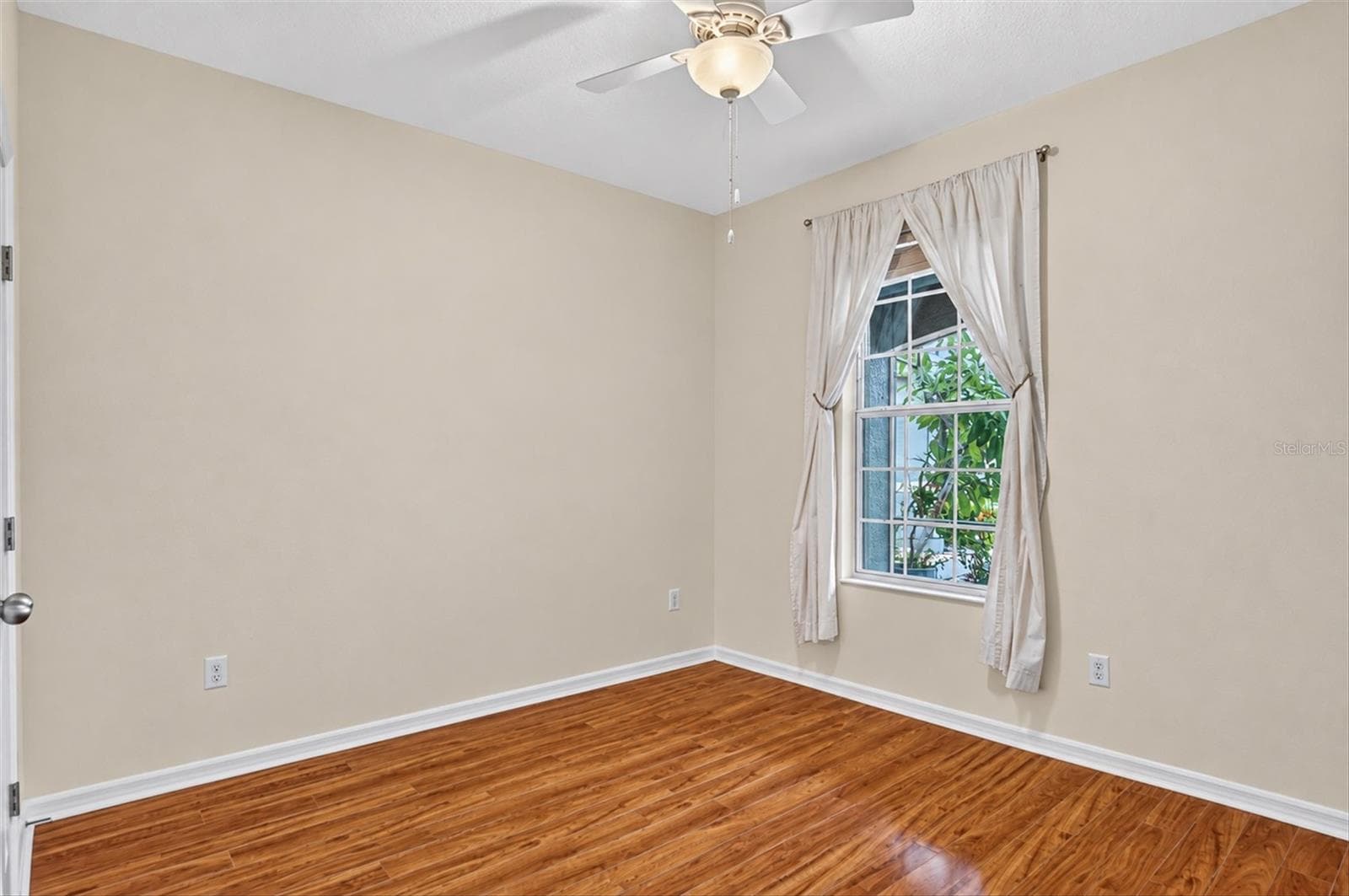 Bright bedroom with a window, ceiling fan and hardwood flooring. - 2153 BARRACUDA CT, HOLIDAY