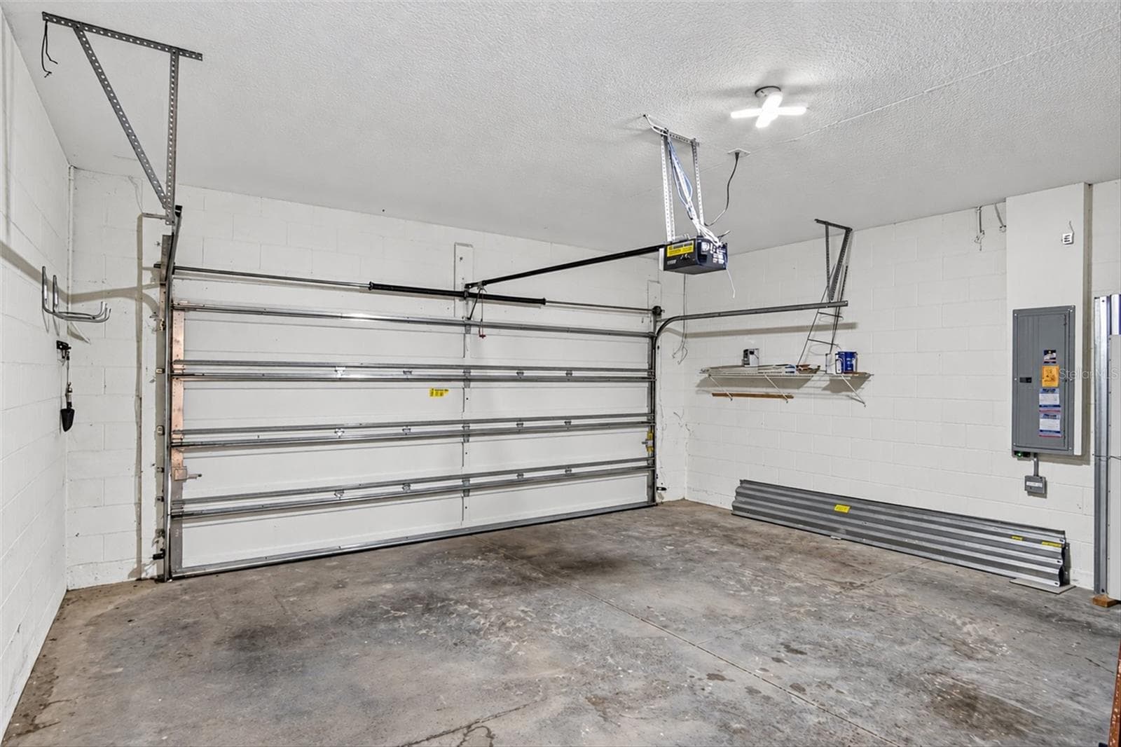 Attached two-car garage with overhead storage and utility space. - 2153 BARRACUDA CT, HOLIDAY