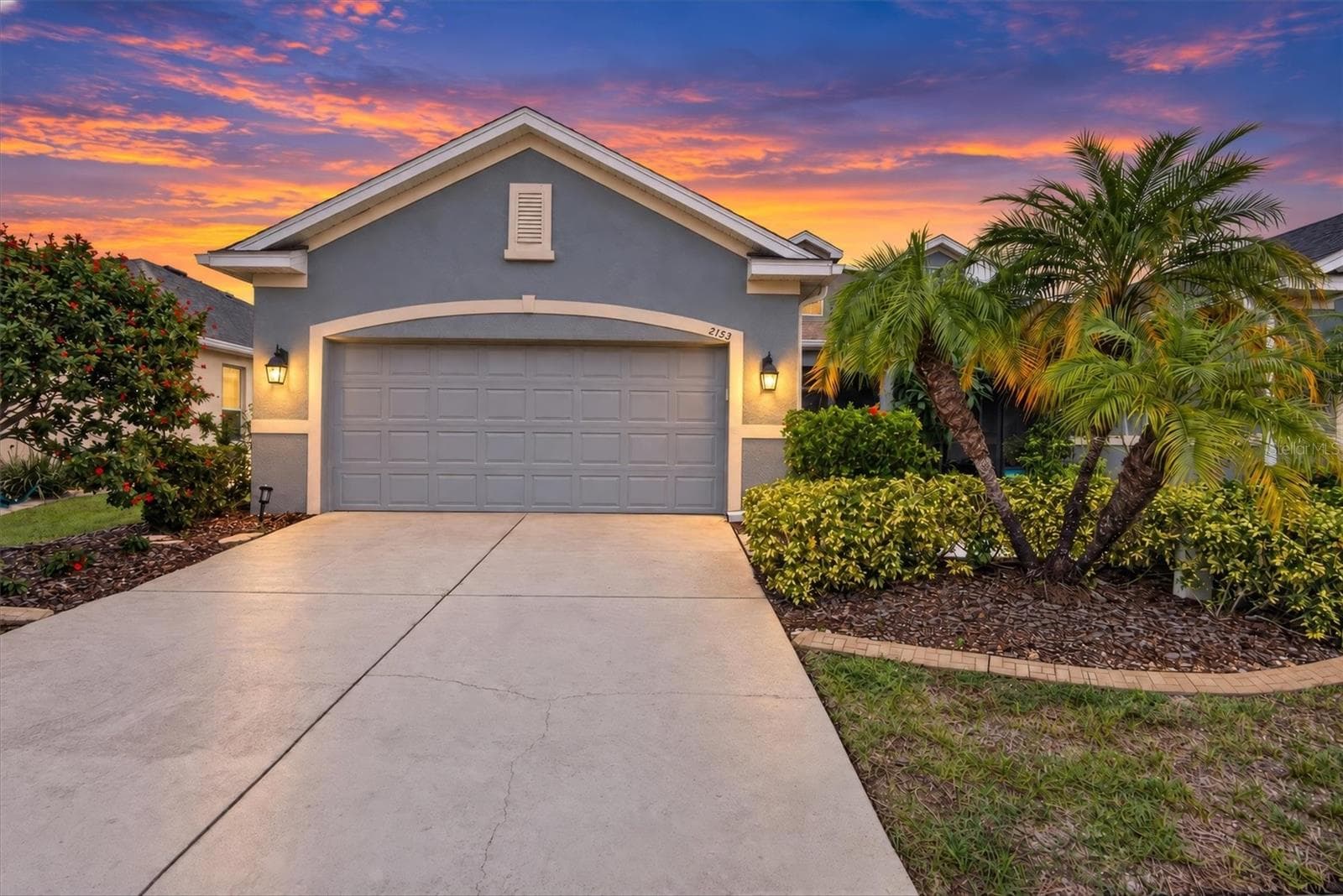 Twilight view of the home's exterior and landscaped front yard. - 2153 BARRACUDA CT, HOLIDAY