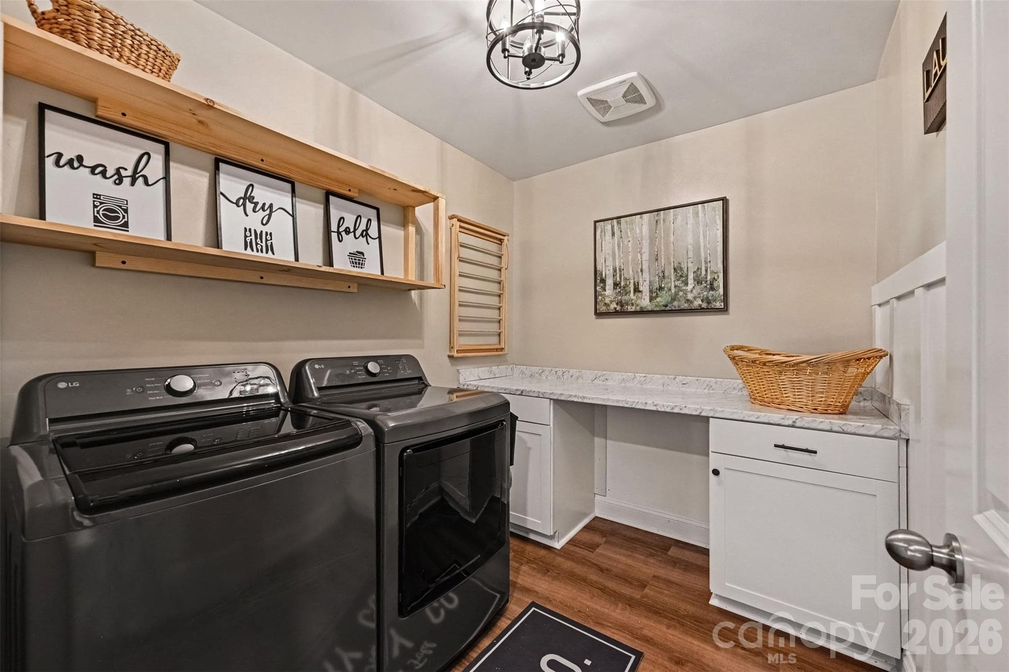 A laundry room with a built-in folding counter and shelving, so laundry day hurts a little less. - 2703 Wedgewood Court, Denver