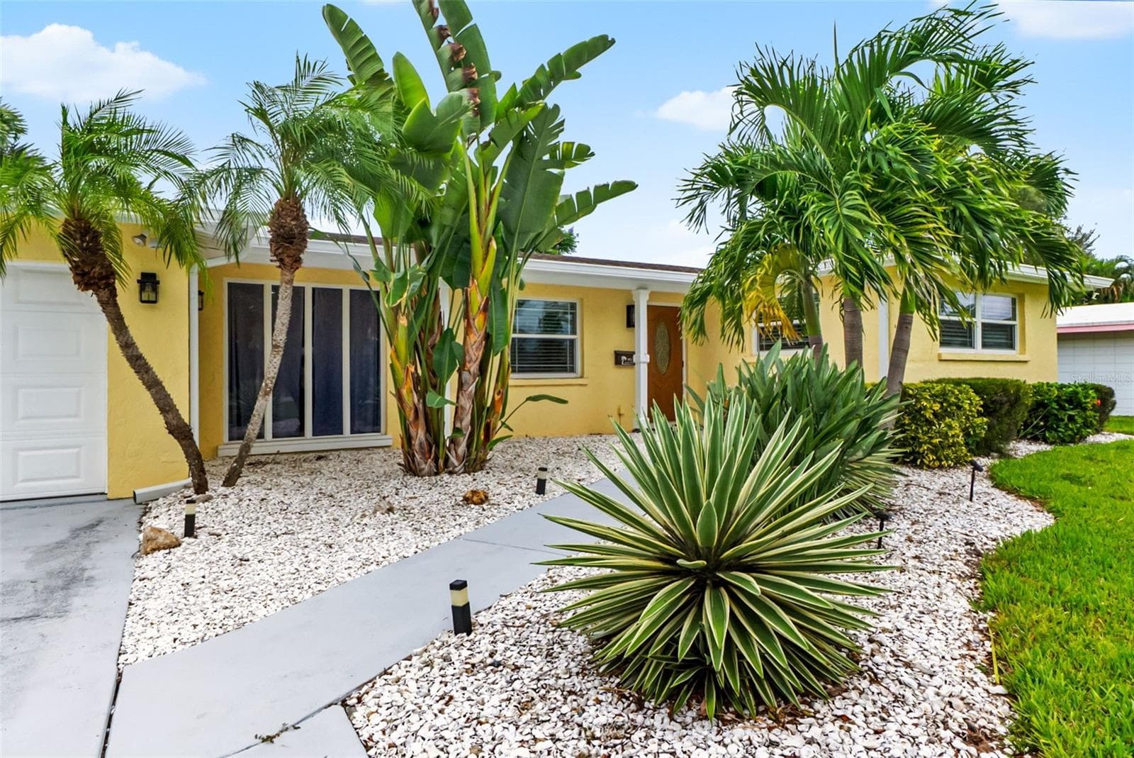 Tropical landscaping frames the front of the home. - 912 CHURCH ST, VENICE