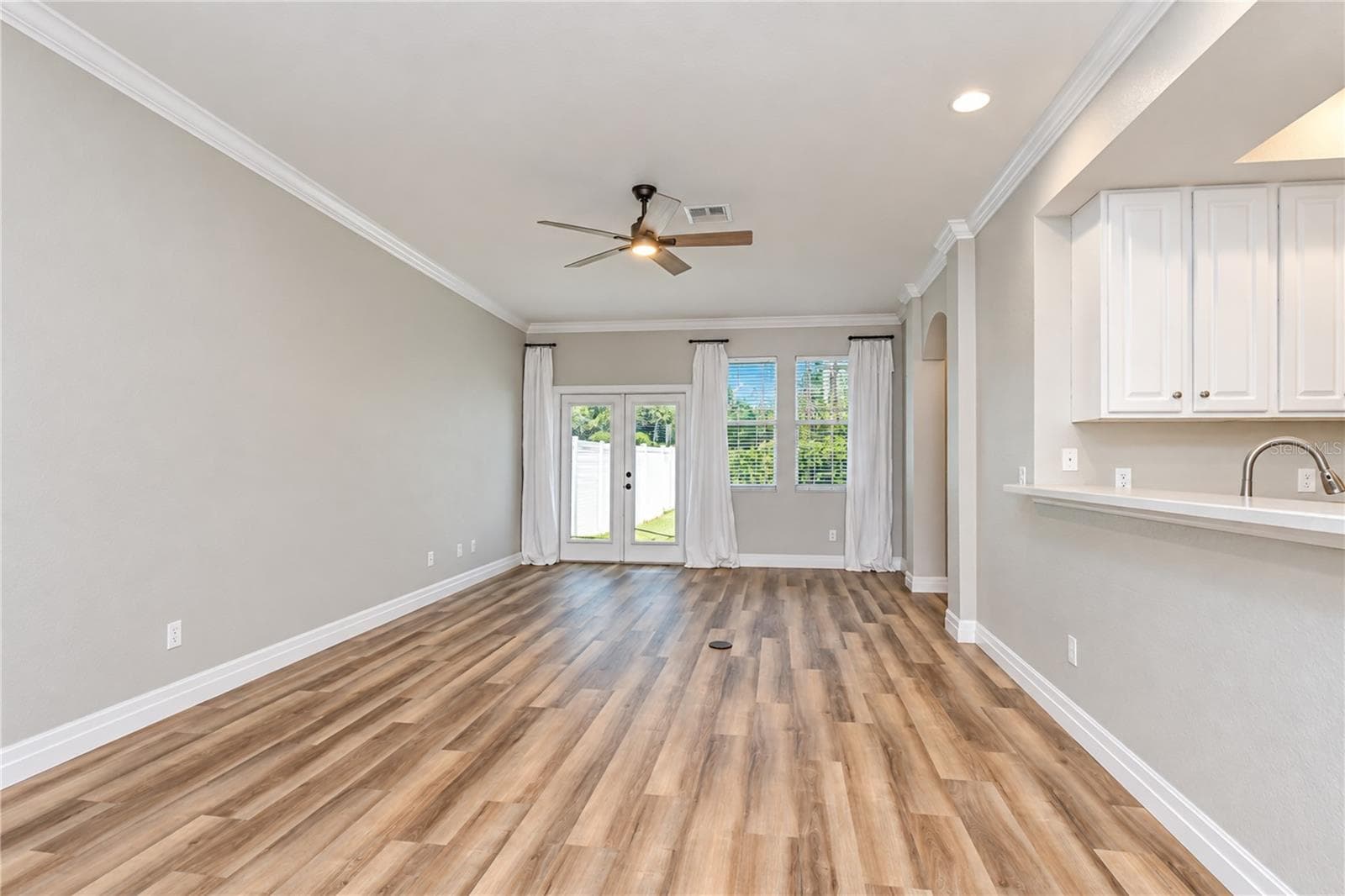 Living room French doors open to the private patio and fenced backyard. - 828 LUMSDEN RESERVE DR, BRANDON