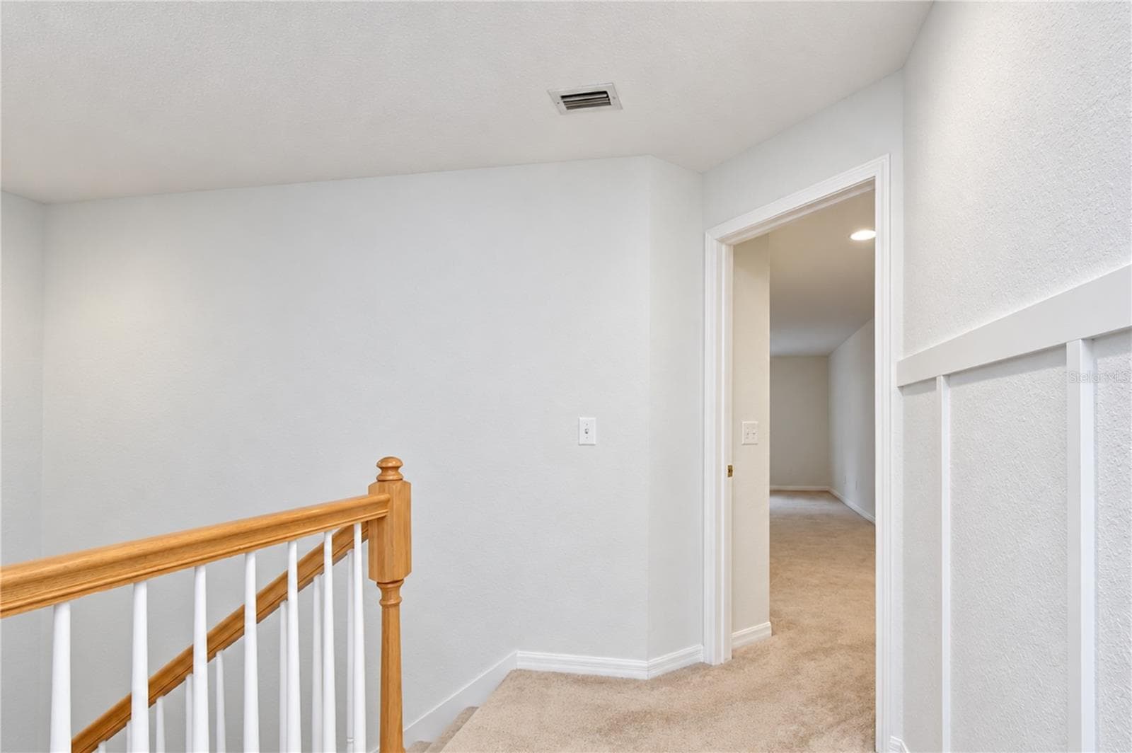 Hallway leading to secondary bedrooms and upper-level living spaces. - 828 LUMSDEN RESERVE DR, BRANDON