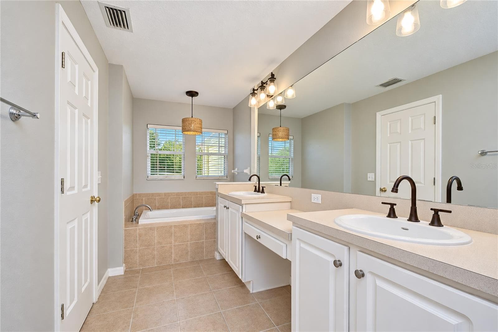 Primary bath features dual sinks, a garden soaking tub, and a separate walk-in shower. - 828 LUMSDEN RESERVE DR, BRANDON