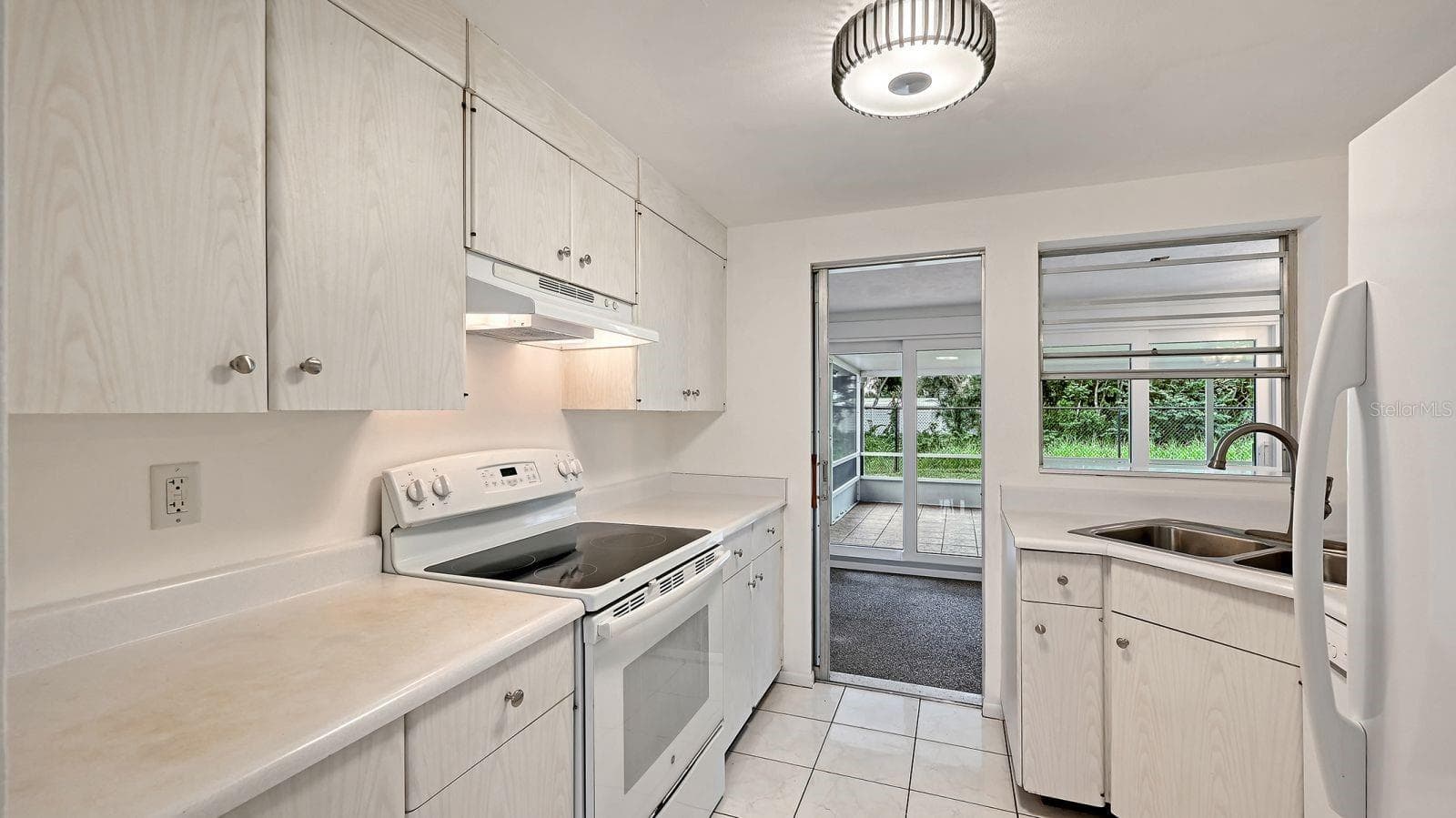 Kitchen with pass thru window and door to the Florida Room - 2610 REGATTA DR, SARASOTA