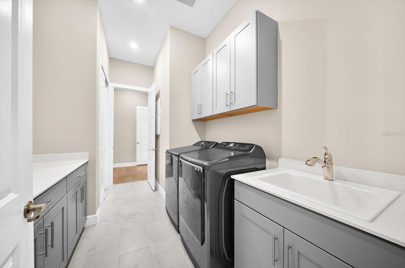 Large laundry room with laundry sink and lots of storage - 10716 SARATOGA PL, PARRISH