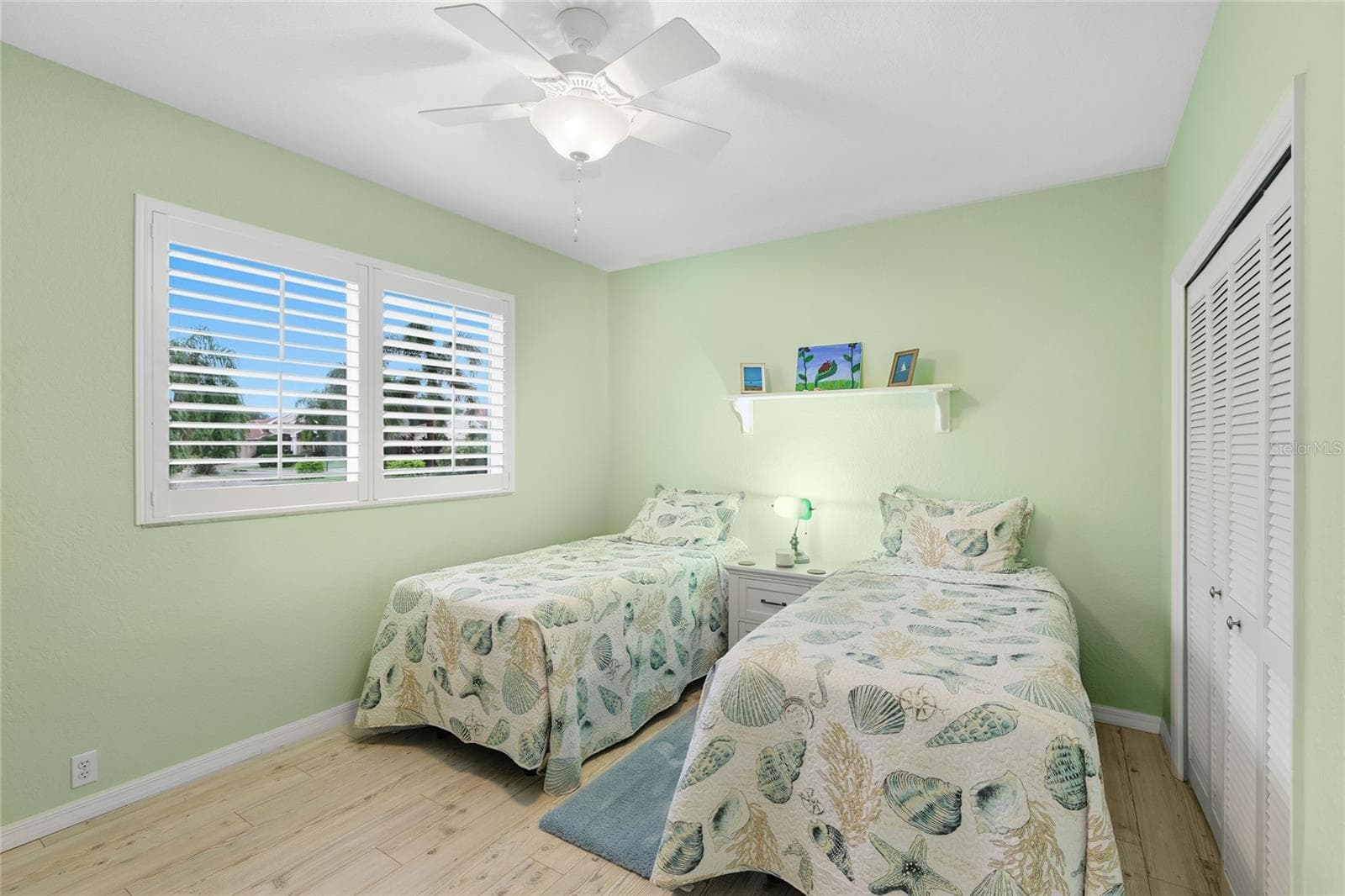 Guest bedroom two features custom louvered shutters, ceiling fan, and baseboard trim. - 3306 LITTLE COUNTRY RD, PARRISH