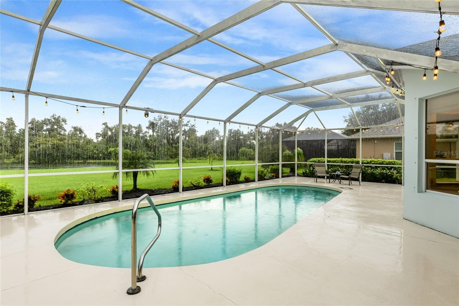 Private in-ground pool with a lake view, featuring a new pool pump, custom landscaping with hard-wired lighting. - 3306 LITTLE COUNTRY RD, PARRISH