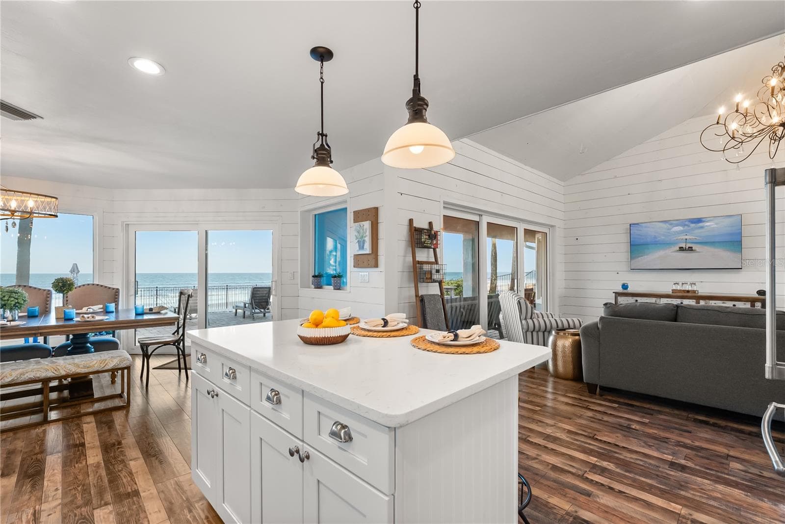 Spacious eat-in kitchen with stainless steel appliances, quartz countertops, breakfast bar seating, and beautiful ocean views—an inviting setting for casual meals and gathering. - 2707 S ATLANTIC AVE, DAYTONA BEACH SHORES