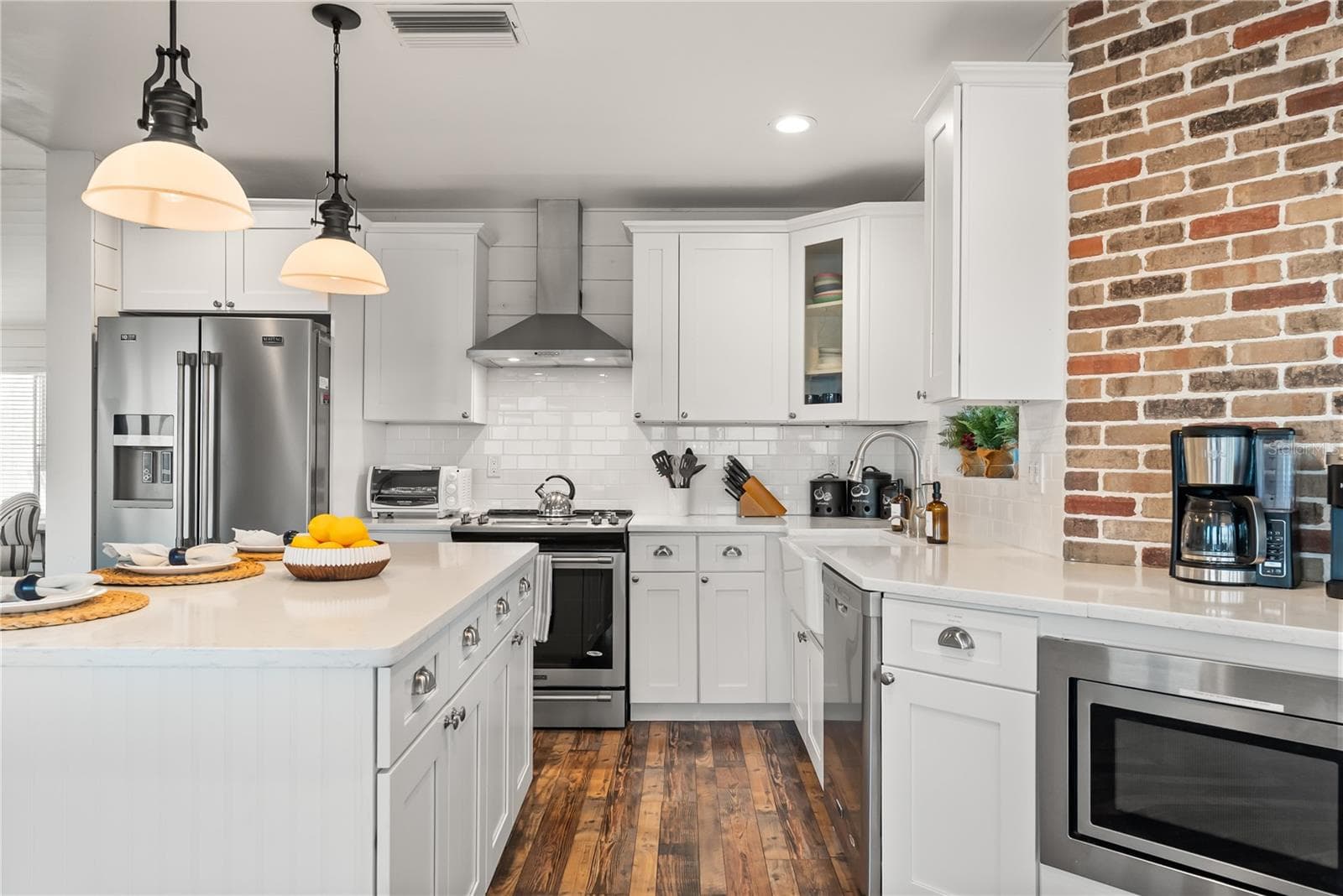 Spacious eat-in kitchen with stainless steel appliances, quartz countertops, breakfast bar seating, and beautiful ocean views—an inviting setting for casual meals and gathering. - 2707 S ATLANTIC AVE, DAYTONA BEACH SHORES