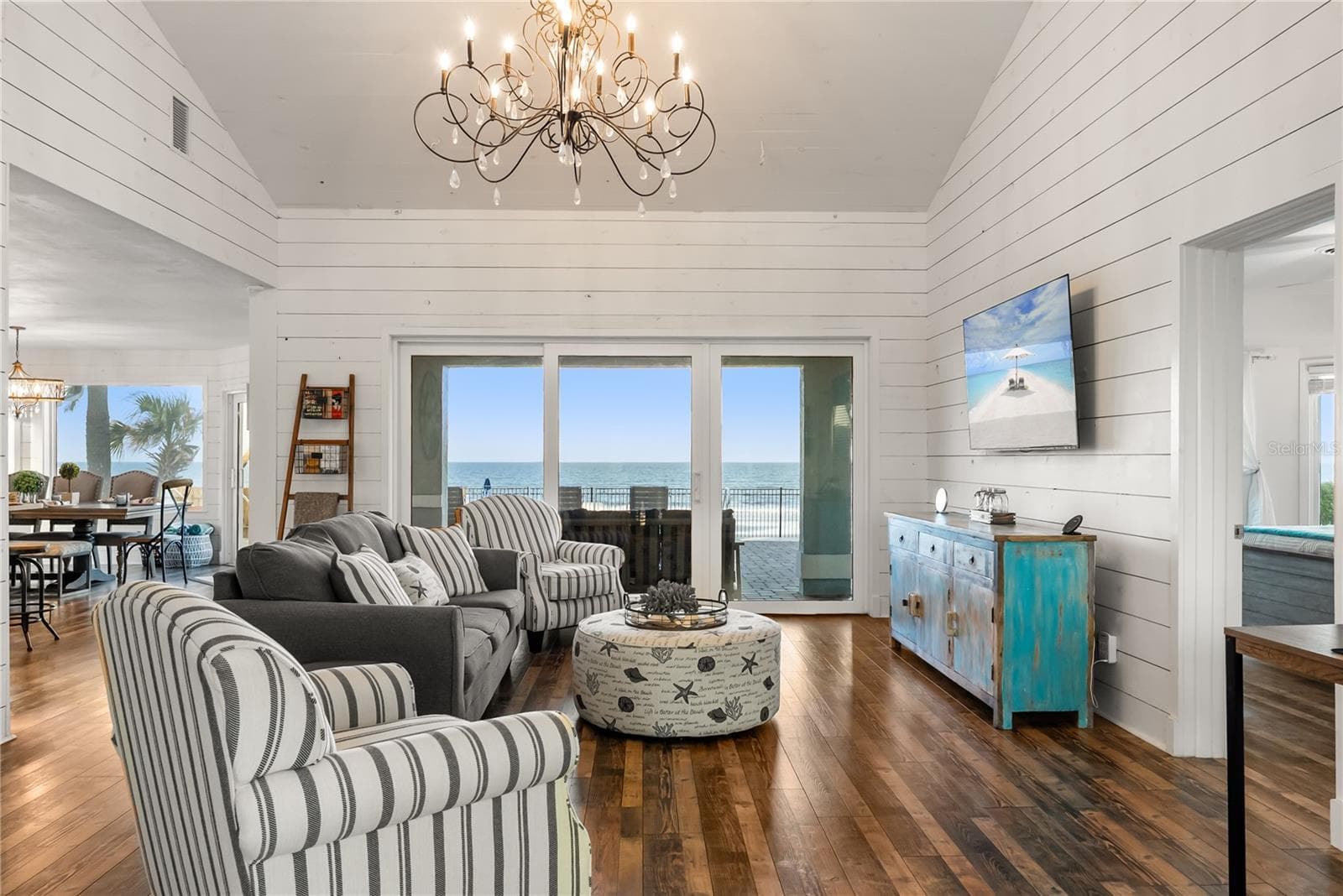 Sweeping Atlantic views take center stage in this bright family room, complemented by coastal furnishings and luxury vinyl plank flooring. - 2707 S ATLANTIC AVE, DAYTONA BEACH SHORES
