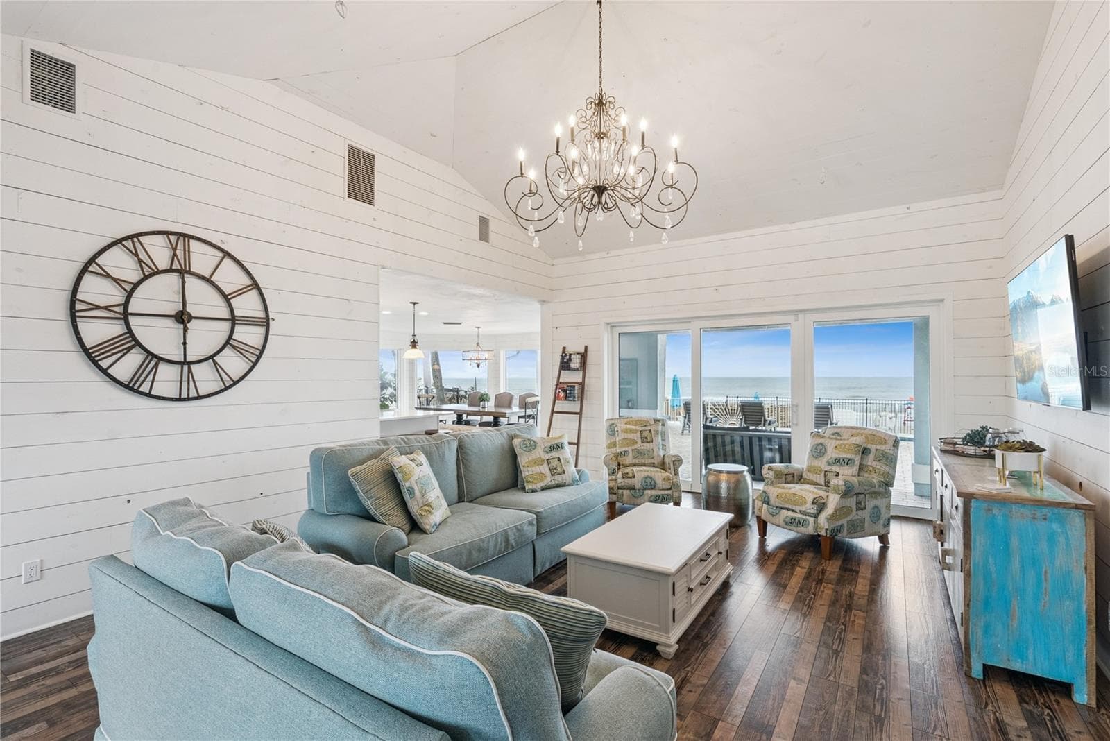 Sweeping Atlantic views take center stage in this bright family room, complemented by coastal furnishings and luxury vinyl plank flooring. - 2707 S ATLANTIC AVE, DAYTONA BEACH SHORES