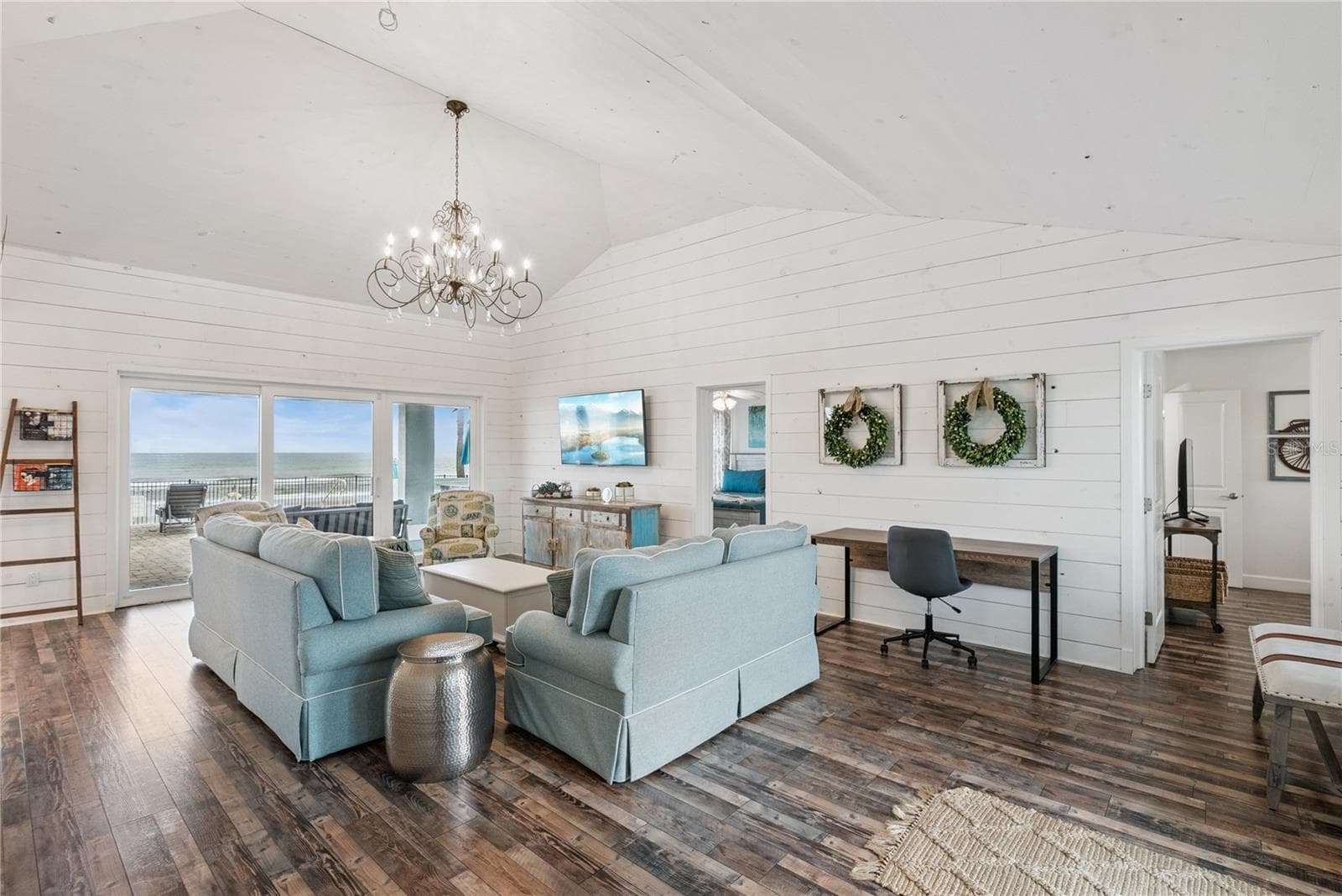 Sweeping Atlantic views take center stage in this bright family room, complemented by coastal furnishings and luxury vinyl plank flooring. - 2707 S ATLANTIC AVE, DAYTONA BEACH SHORES