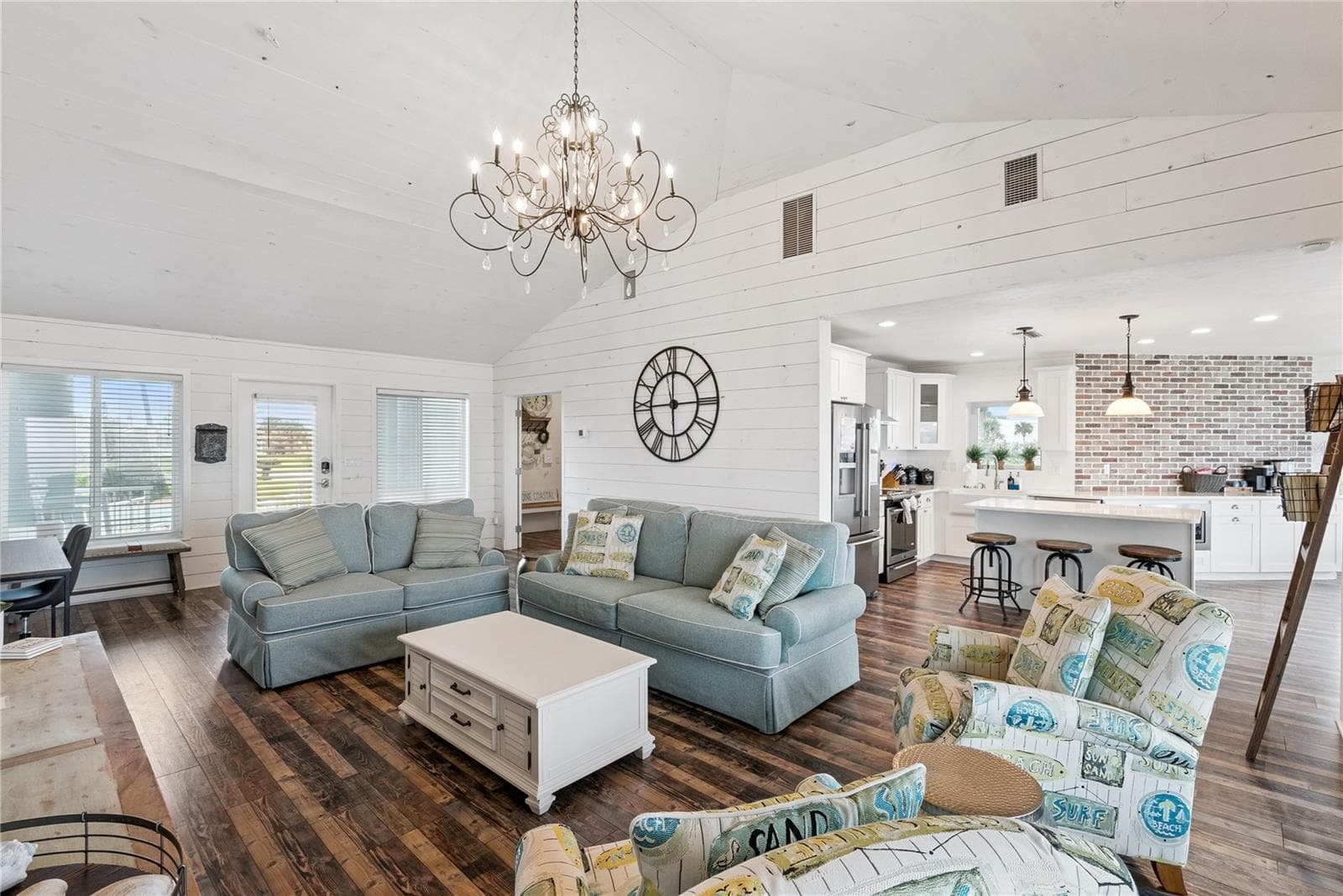 Sweeping Atlantic views take center stage in this bright family room, complemented by coastal furnishings and luxury vinyl plank flooring. - 2707 S ATLANTIC AVE, DAYTONA BEACH SHORES