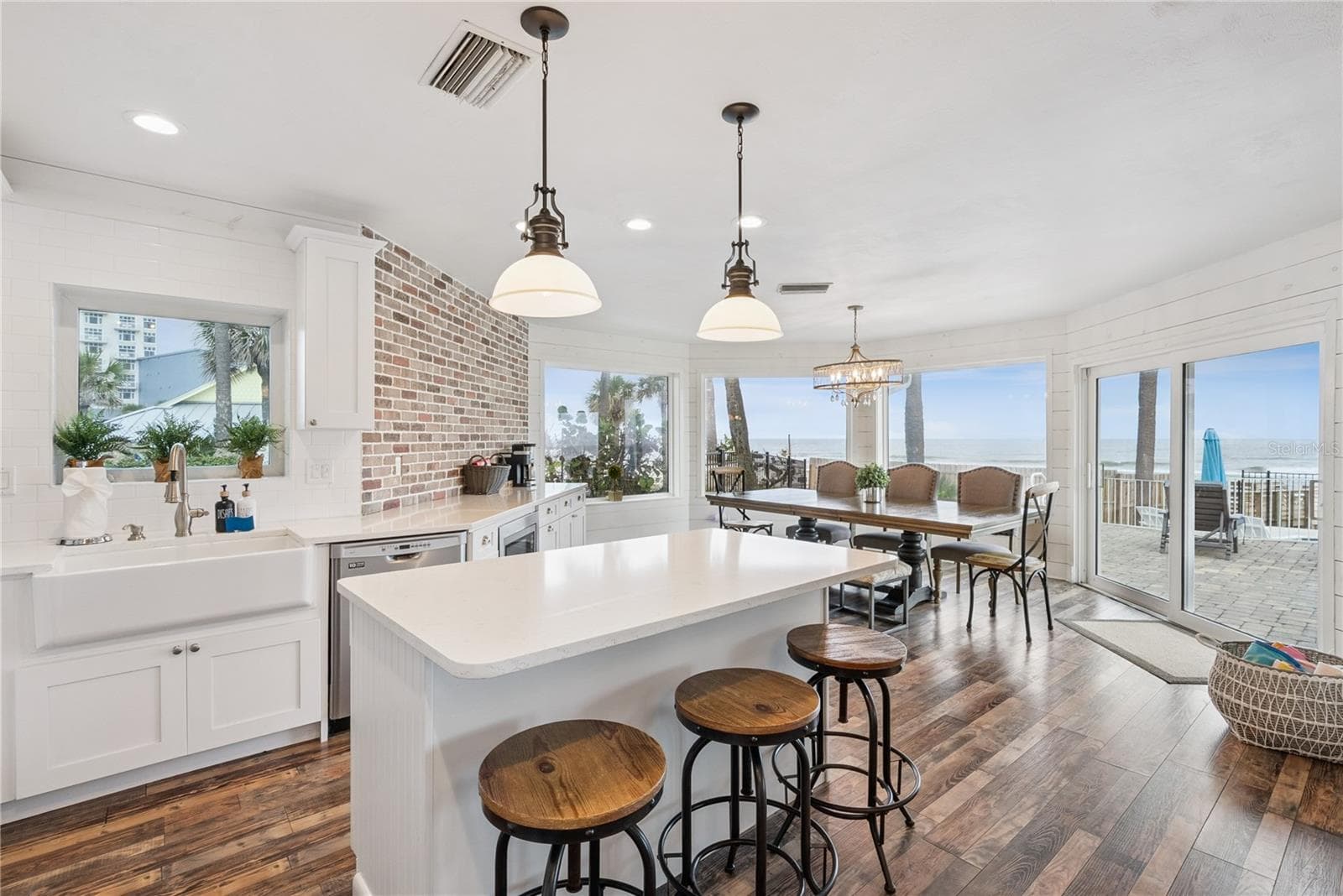 Spacious eat-in kitchen with stainless steel appliances, quartz countertops, breakfast bar seating, and beautiful ocean views—an inviting setting for casual meals and gathering. - 2707 S ATLANTIC AVE, DAYTONA BEACH SHORES