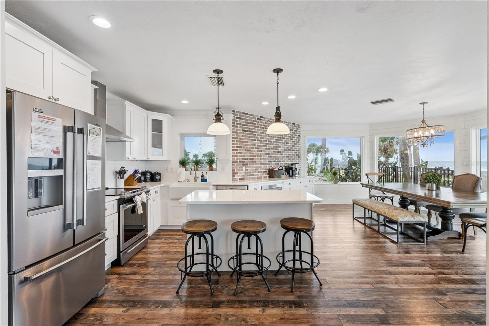 Spacious eat-in kitchen with stainless steel appliances, quartz countertops, breakfast bar seating, and beautiful ocean views—an inviting setting for casual meals and gathering. - 2707 S ATLANTIC AVE, DAYTONA BEACH SHORES