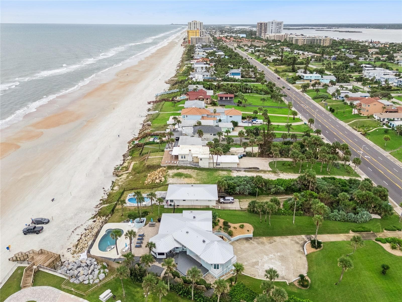 Set on over three-quarters of an acre with approximately 85 feet of ocean frontage, this property offers a generous setback from the road, ample driveway parking, and an attached garage. Neighboring Frank Rendon Park features a playground, covered picnic areas, restrooms, public beach access, and parking. - 2707 S ATLANTIC AVE, DAYTONA BEACH SHORES