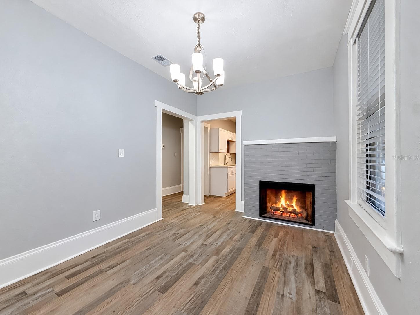 Dining room area with electric fireplace and view into kitchen - 509 27TH AVE S, ST PETERSBURG