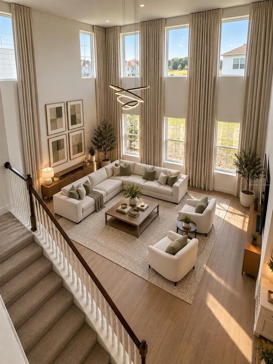 Experience the elegance of model-home living! This spectacular, light-filled living room features soaring double-height ceilings, expansive windows, and an impressive open-concept design. Bathed in natural light, this exceptionally spacious area offers a breathtaking sense of openness, sophistication, and comfort—perfect for luxurious everyday living and entertaining.AI Virtual Staging Disclosure: This image has been virtually staged using artificial intelligence based on an original photograph of the actual living room. Furniture, décor, and decorative elements are digitally generated for illustrative purposes and are not included with the rental property. - 5714 CATTLE RANCH DR, ST CLOUD