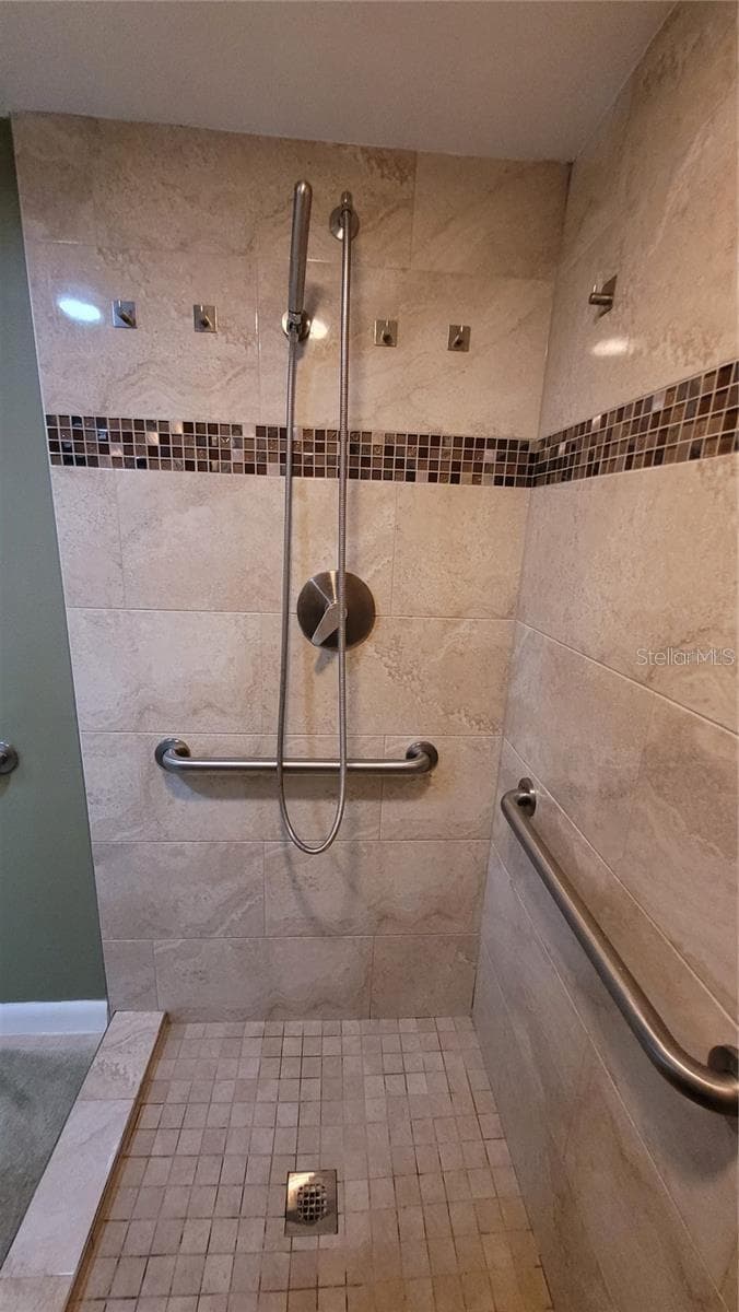 The primary bath suite has a custom designed walk in tiled shower with plenty of grab bars for safety - 1806 MARINER DR #318, TARPON SPRINGS