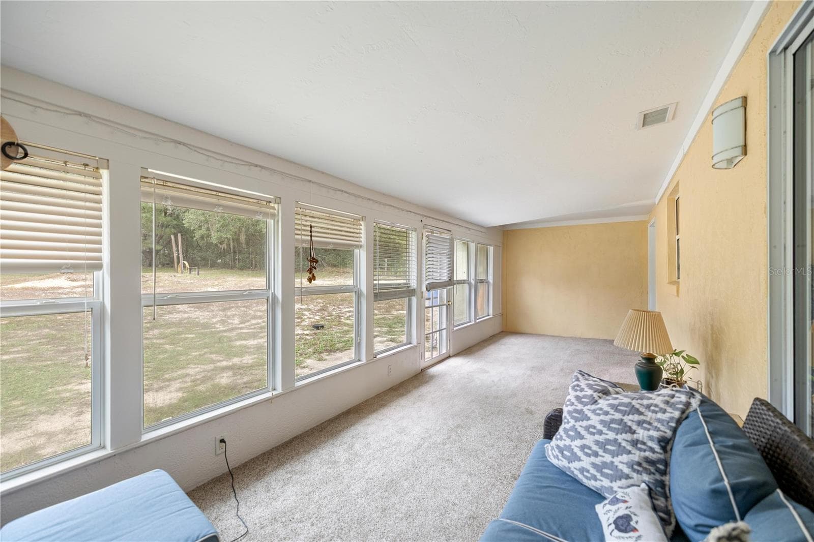 SUNROOM PREPPING STUFF  TO MOVE & LOOKING PAST KITCHEN PASS-THRU WINDOW TO INSIDE LAUNDRY ROOM DOOR - 7910 SW 202ND CT, DUNNELLON