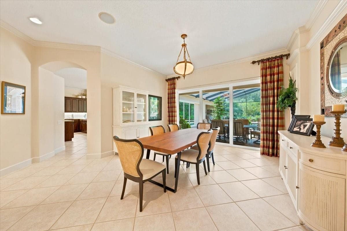 Large sliders frame views of the screened lanai, pool, and lush backyard. - 5513 KEELER OAK ST, LITHIA