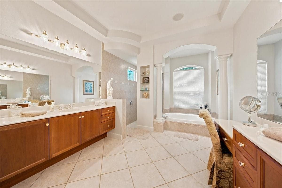 Spacious en-suite bathroom features separate vanities, a soaking tub, and a walk-in shower. - 5513 KEELER OAK ST, LITHIA