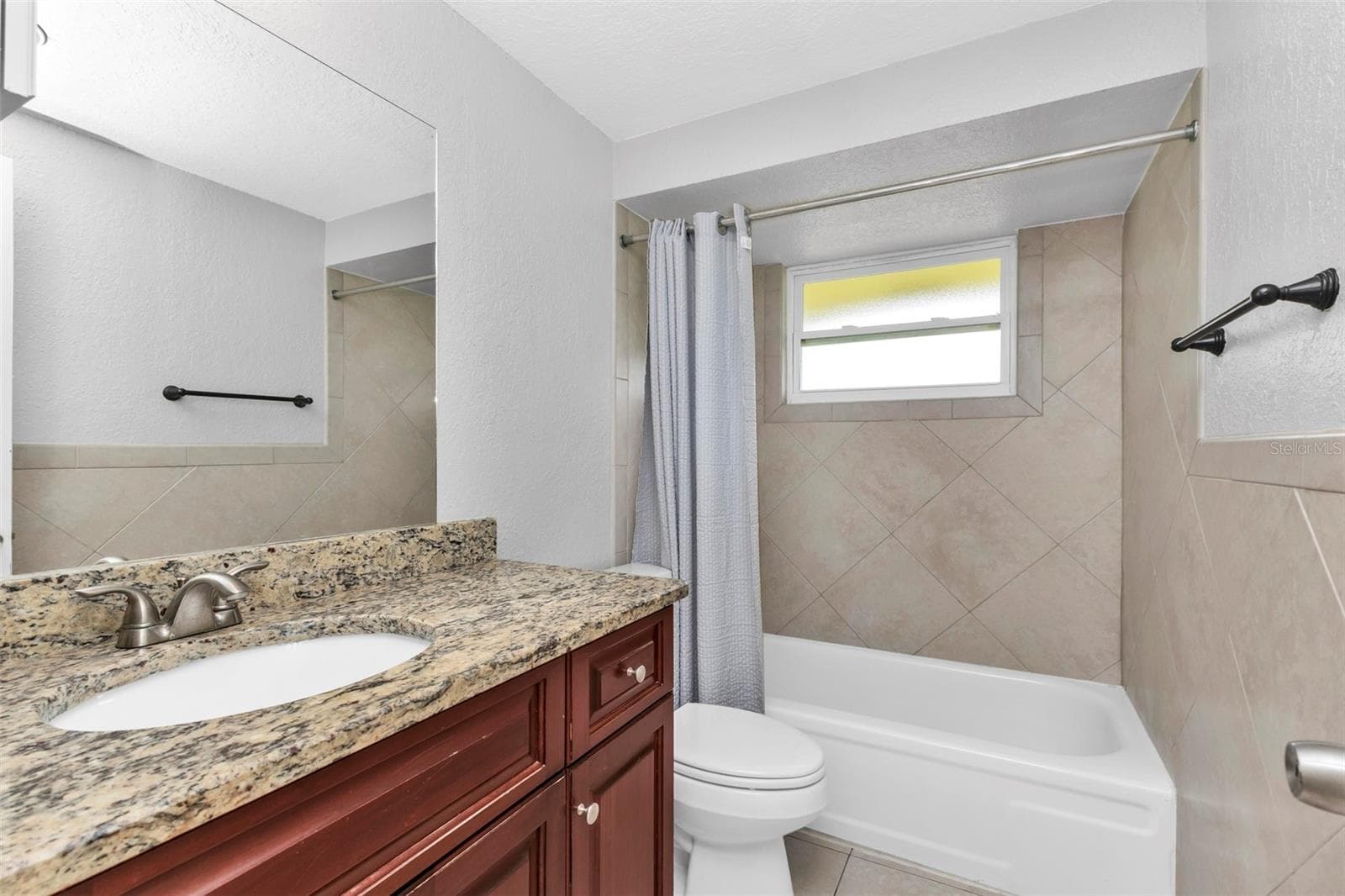 Guest bathroom features single vanity with a shower/tub combo. - 424 VANNELL ST, PORT CHARLOTTE