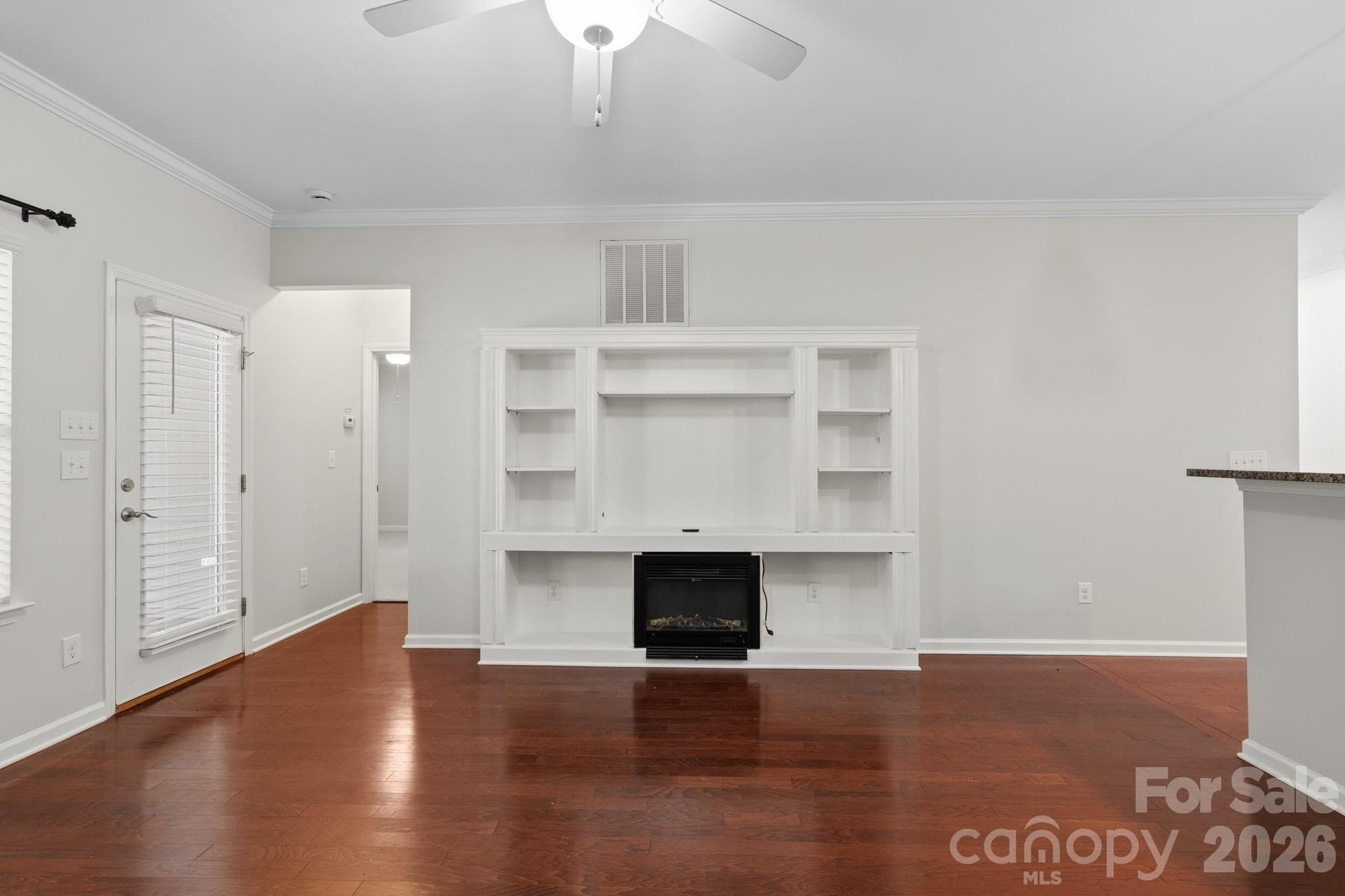 living room with built-in entertainment center, shelving and electric fireplace. - 24526 Blue Heron Circle, Lancaster