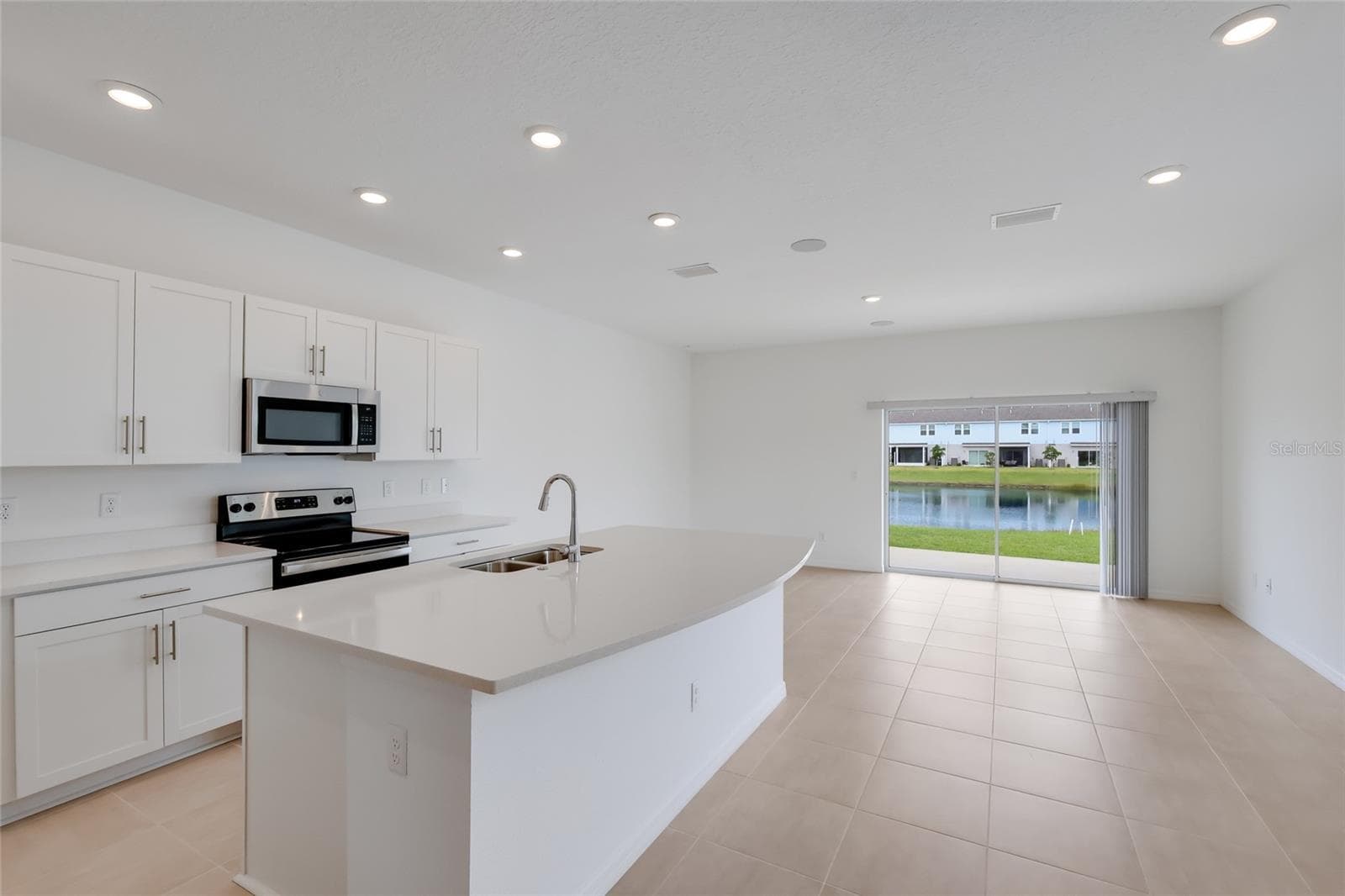 The gorgeous white cabinets and white quartz countertops make the inside bright and airy. The lake views from the kitchen and the family room are second-to-none! - 15150 GINETTI ST, NOKOMIS