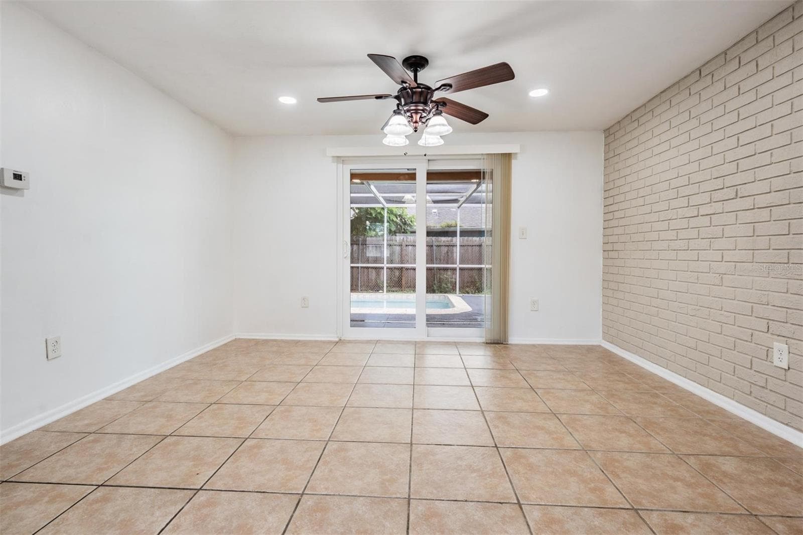 View of dining area looking out to the pool - 7700 BIRCHWOOD DR, PORT RICHEY