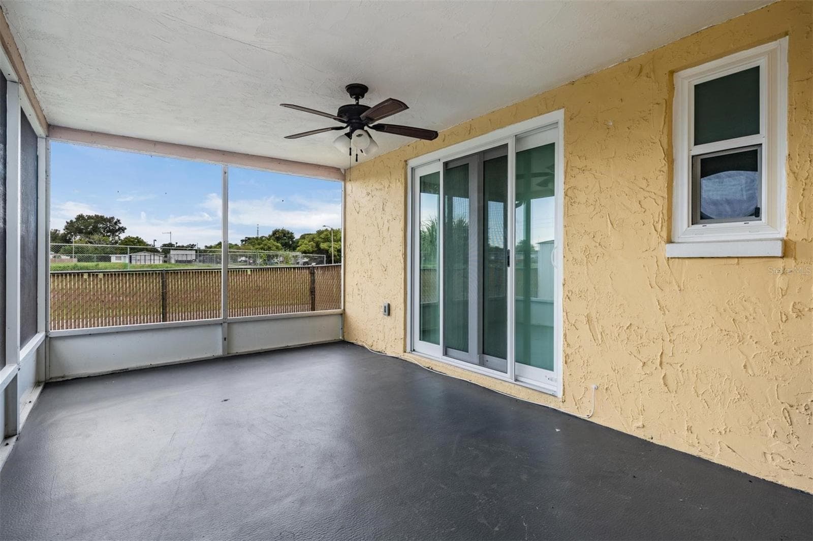 Looking back at primary bedroom slider and patio seating area - 7700 BIRCHWOOD DR, PORT RICHEY