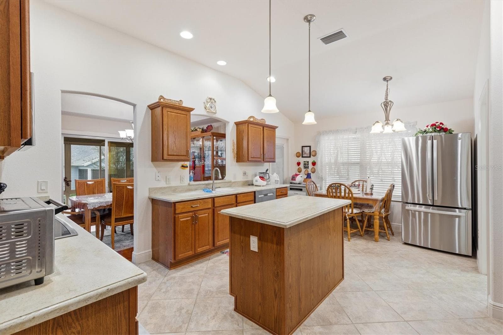 Large Kitchen with two refrigerators, built-in oven, cooktop, and working island. - 1926 ELDRIDGE LOOP, THE VILLAGES