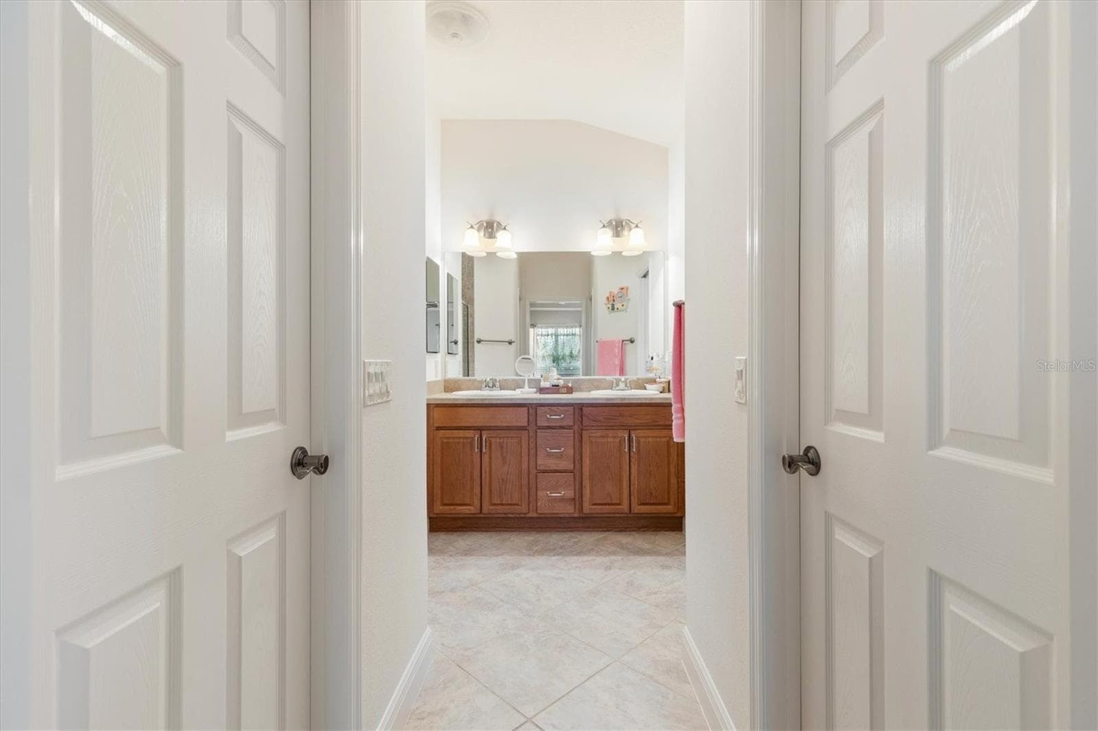 Primary ensuite with two walk-in closets, walk-in shower, dual sinks, and private water closet. - 1926 ELDRIDGE LOOP, THE VILLAGES
