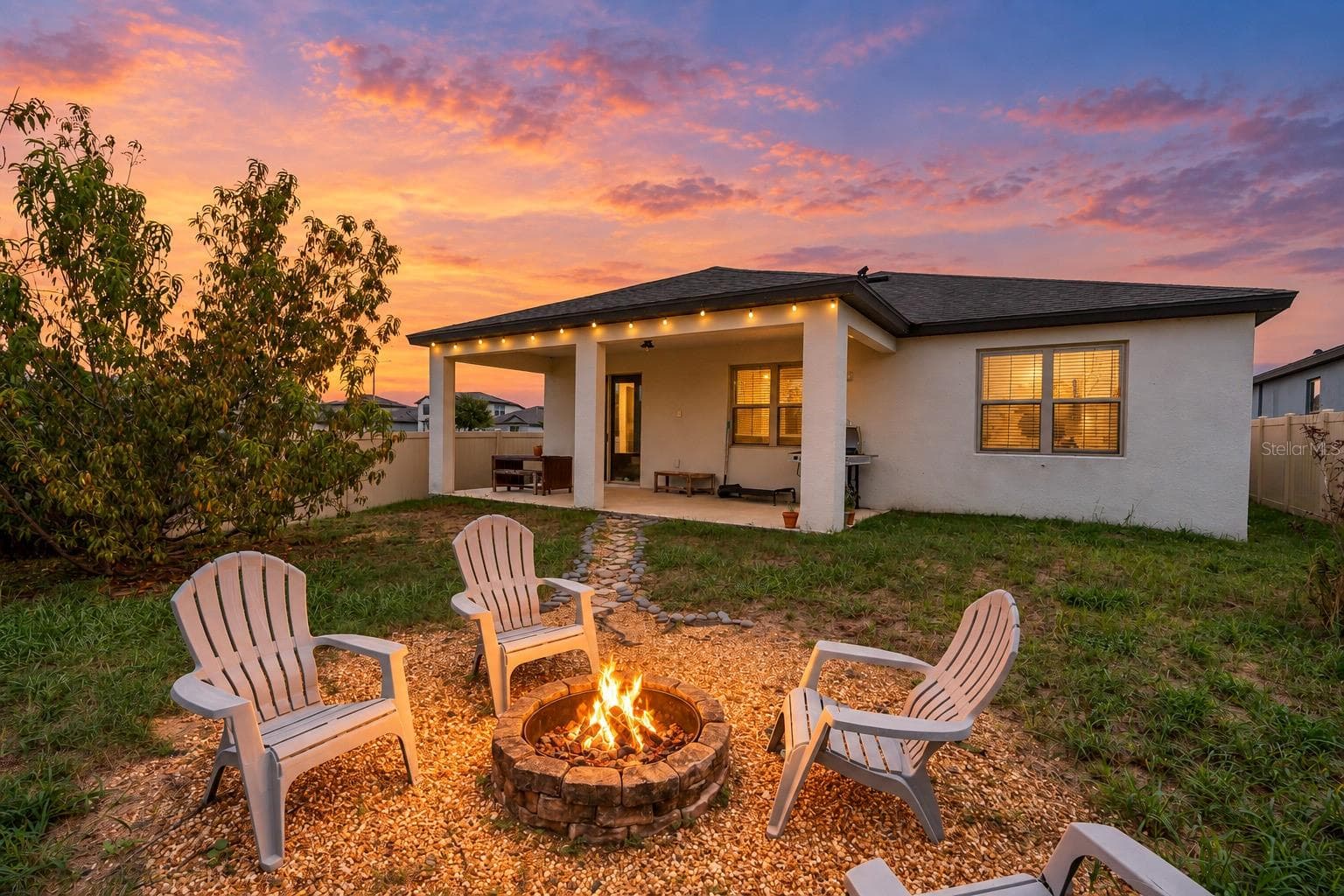 twilight of rear patio, yard and fireplace - 272 CITRUS ISLE LOOP, DAVENPORT