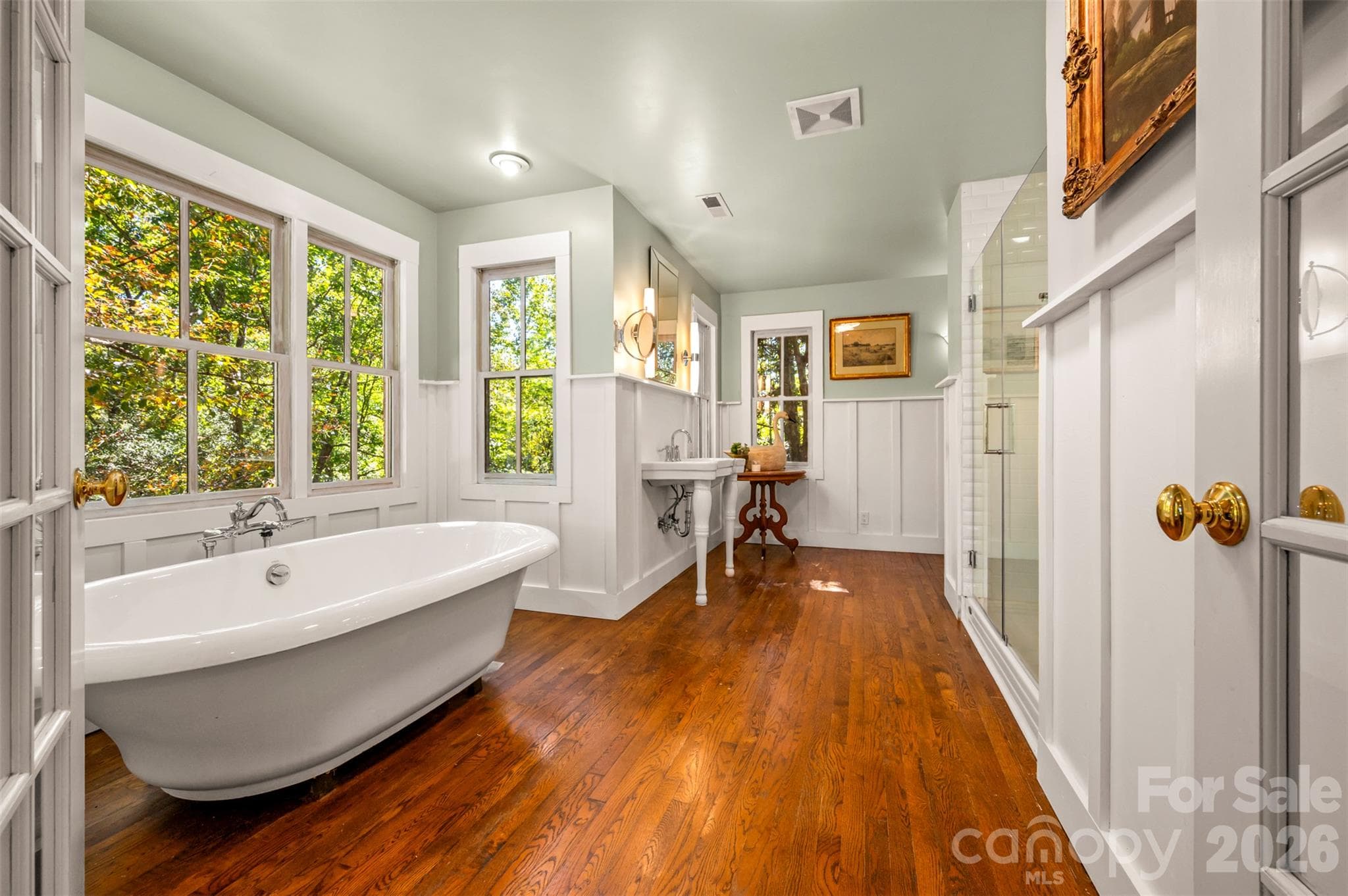Ensuite bathroom with soaking tub surrounded by windows overlooking tree canopy. - 600 John Weaver Road, Columbus