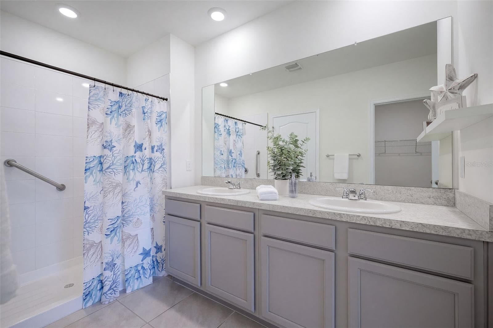 The Primary En-suite bathroom features a comfort-height vanity with dual sinks & a linen closet - 2415 BRASSIE CT, WINTER HAVEN
